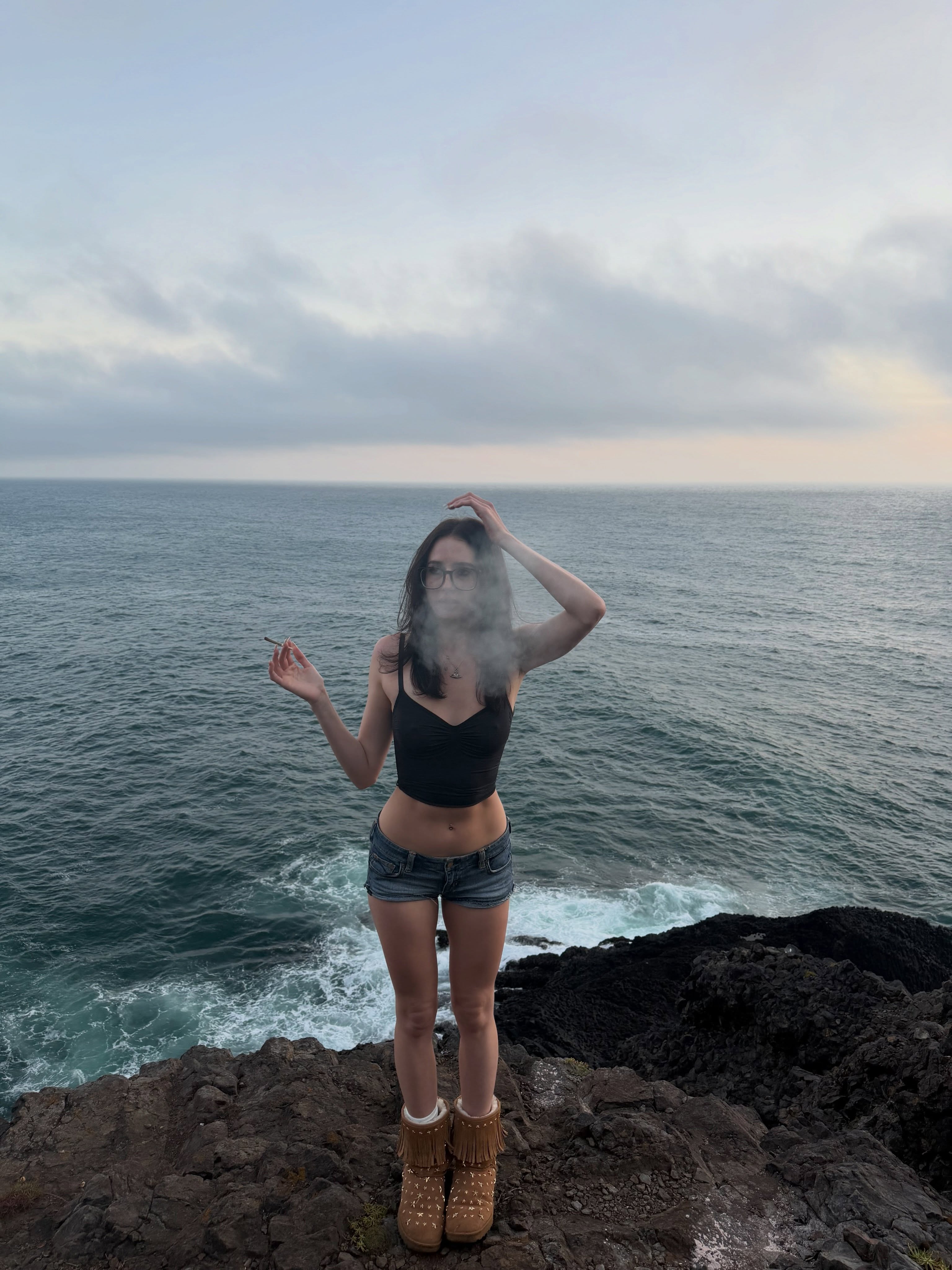 alyssapearls wearing black crop top in rocky cliff by the ocean
