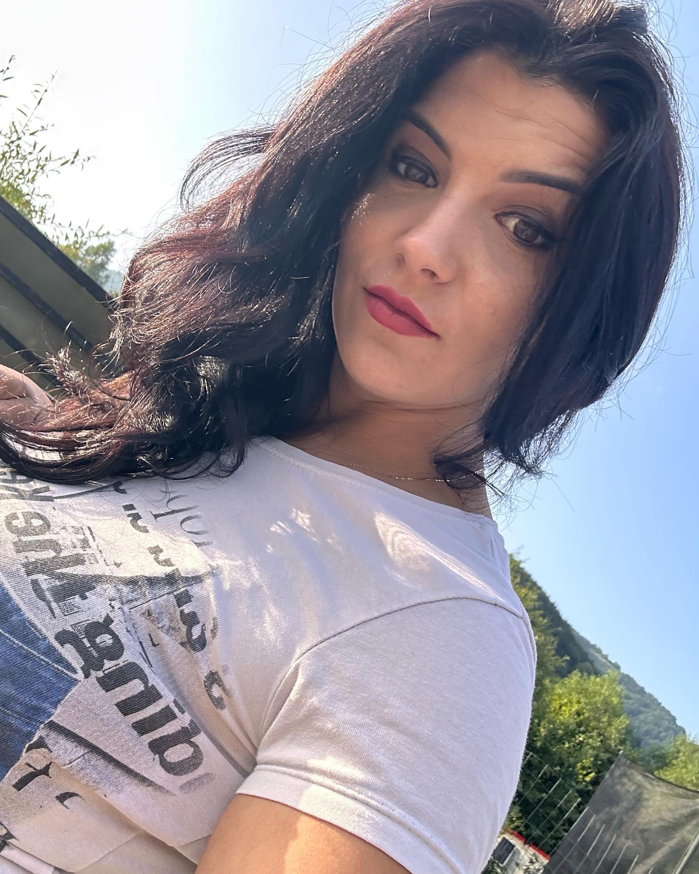 anaworld69 posing for a selfie wearing white graphic t-shirt