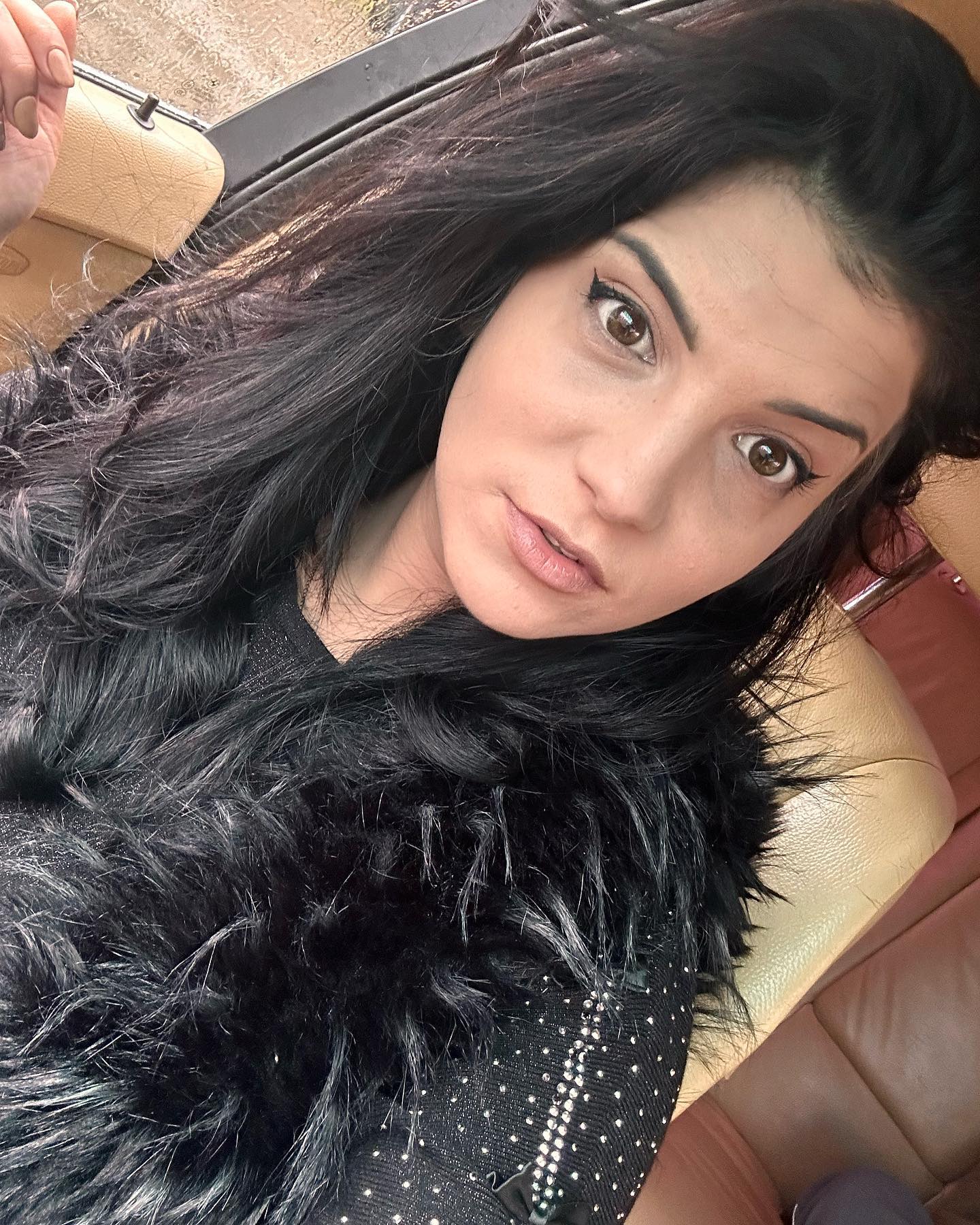 anaworld69 taking a selfie wearing black faux fur collar in car interior