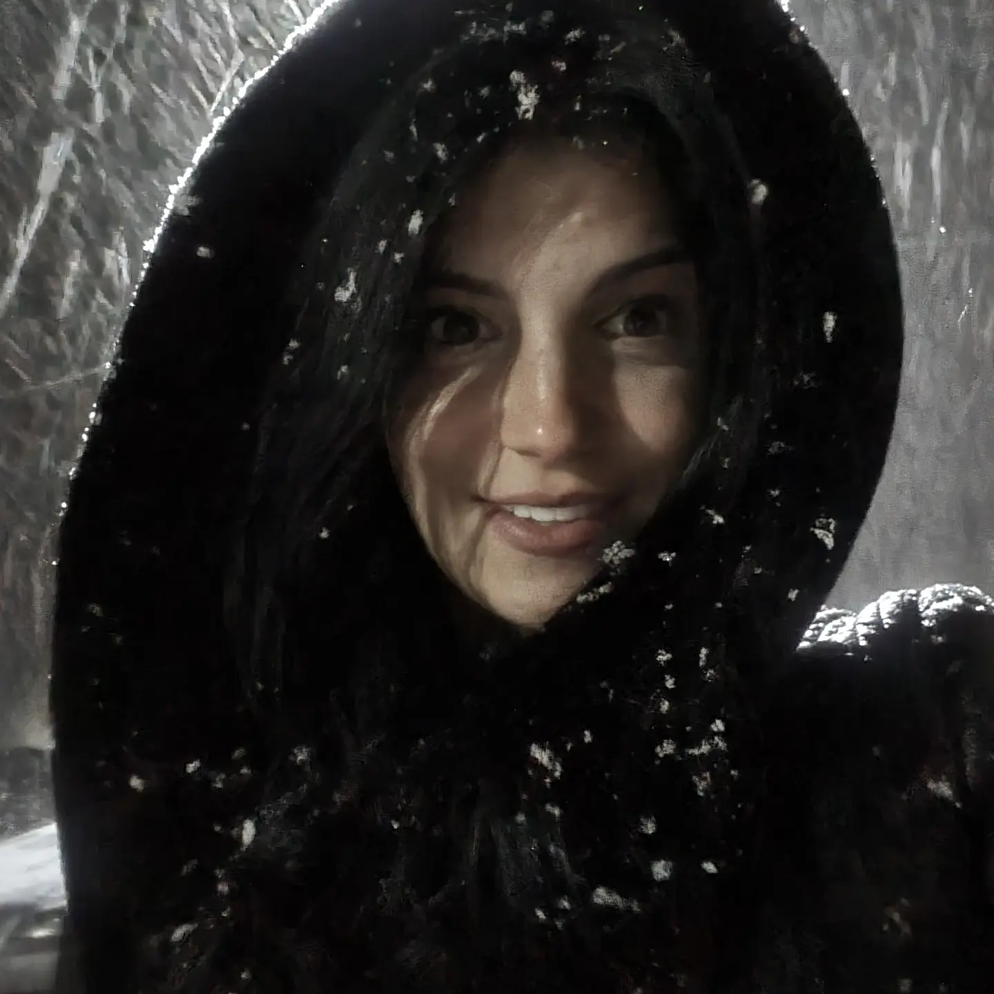 anaworld69 smiling at camera wearing black hooded coat in snow