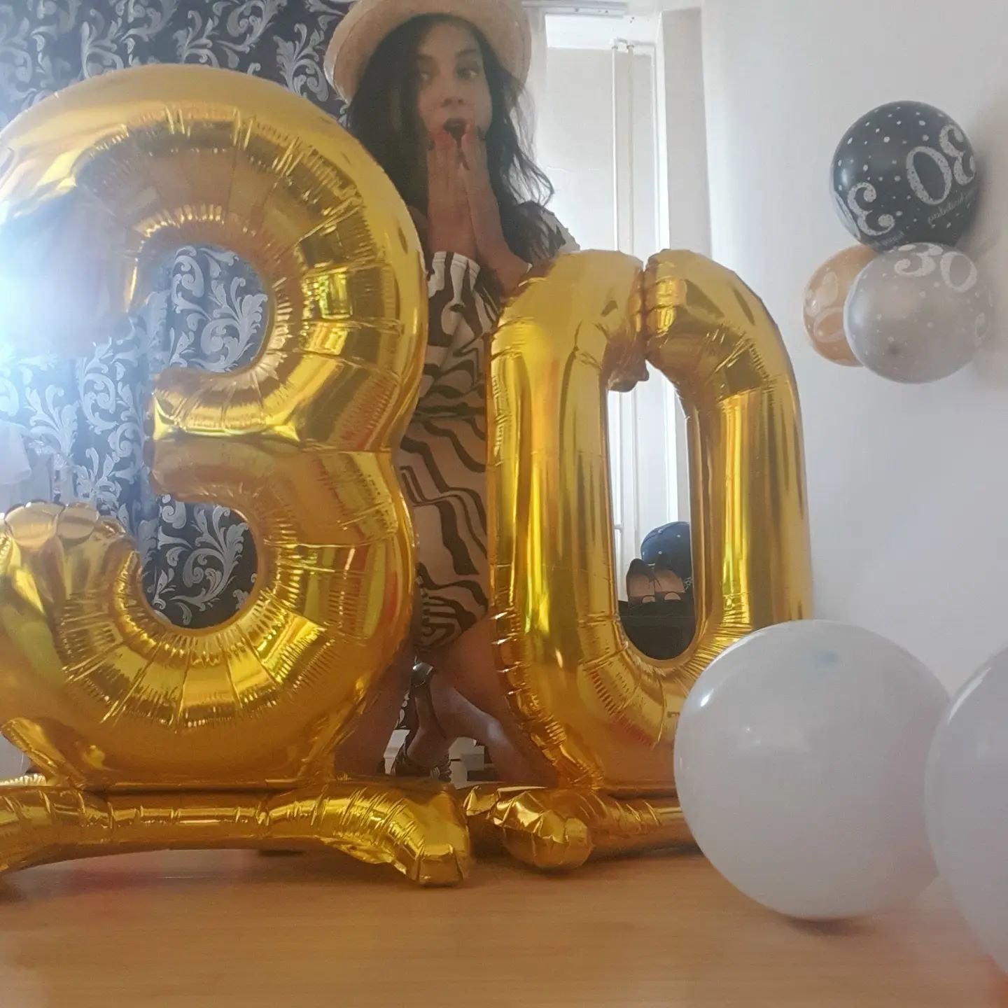 anaworld69 posing behind balloons wearing patterned dress in room