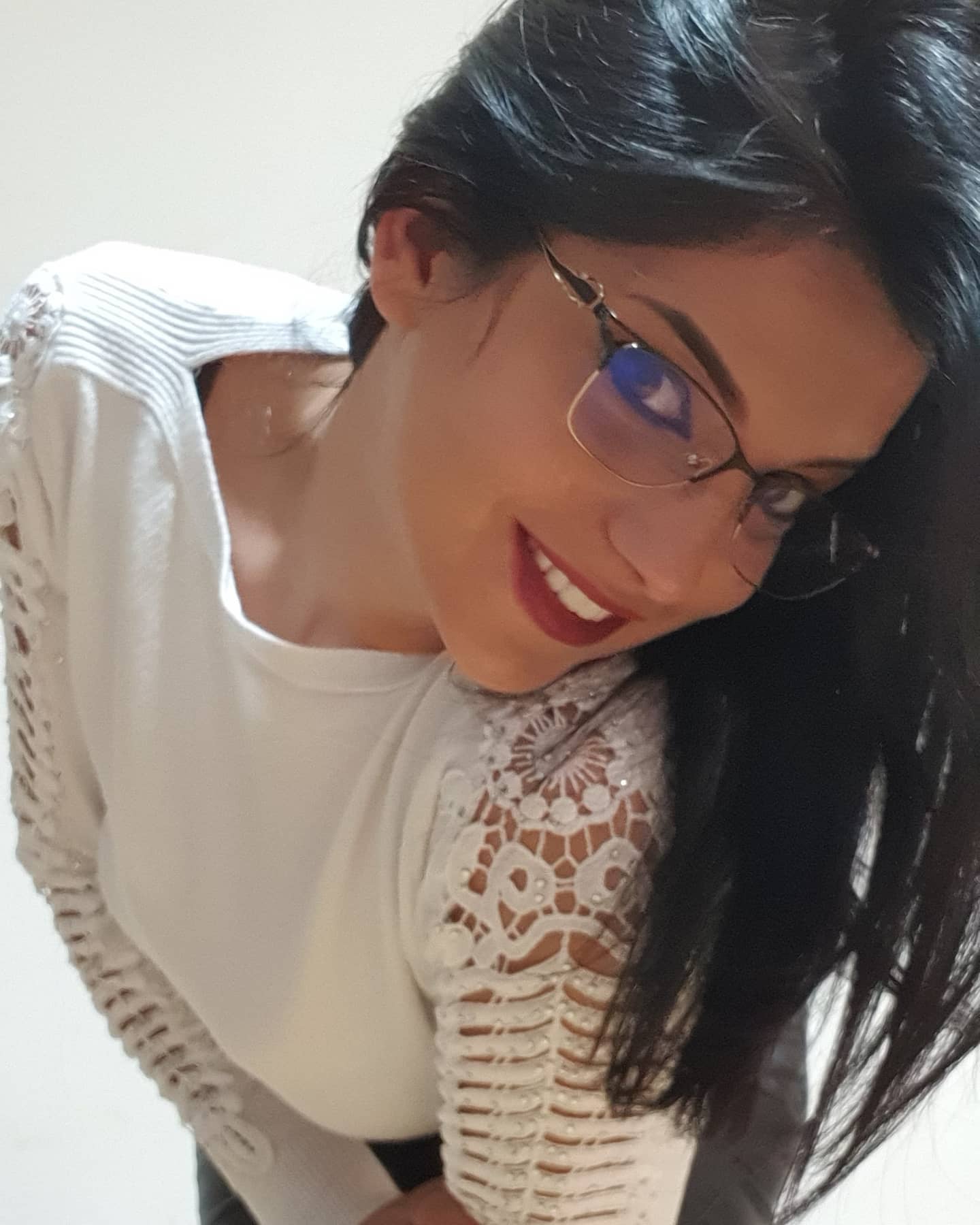 anaworld69 smiling at the camera wearing white lace-sleeve top