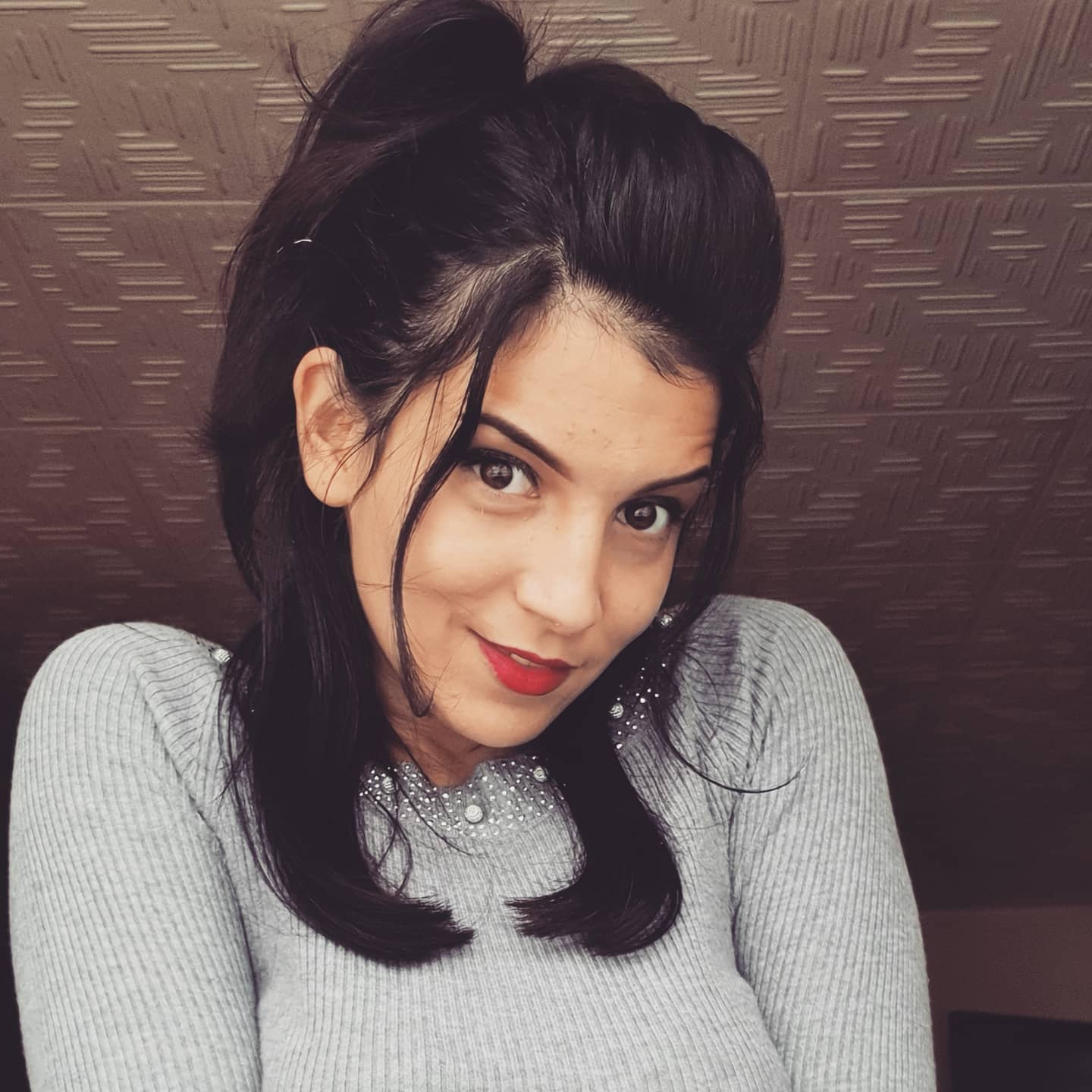 anaworld69 smiling at camera wearing grey ribbed sweater