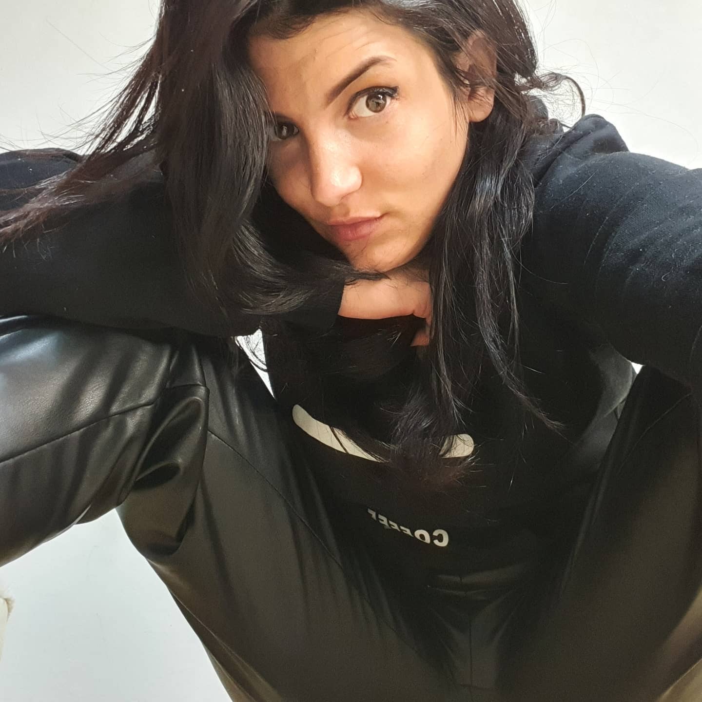 anaworld69 crouching towards the camera wearing black hoodie