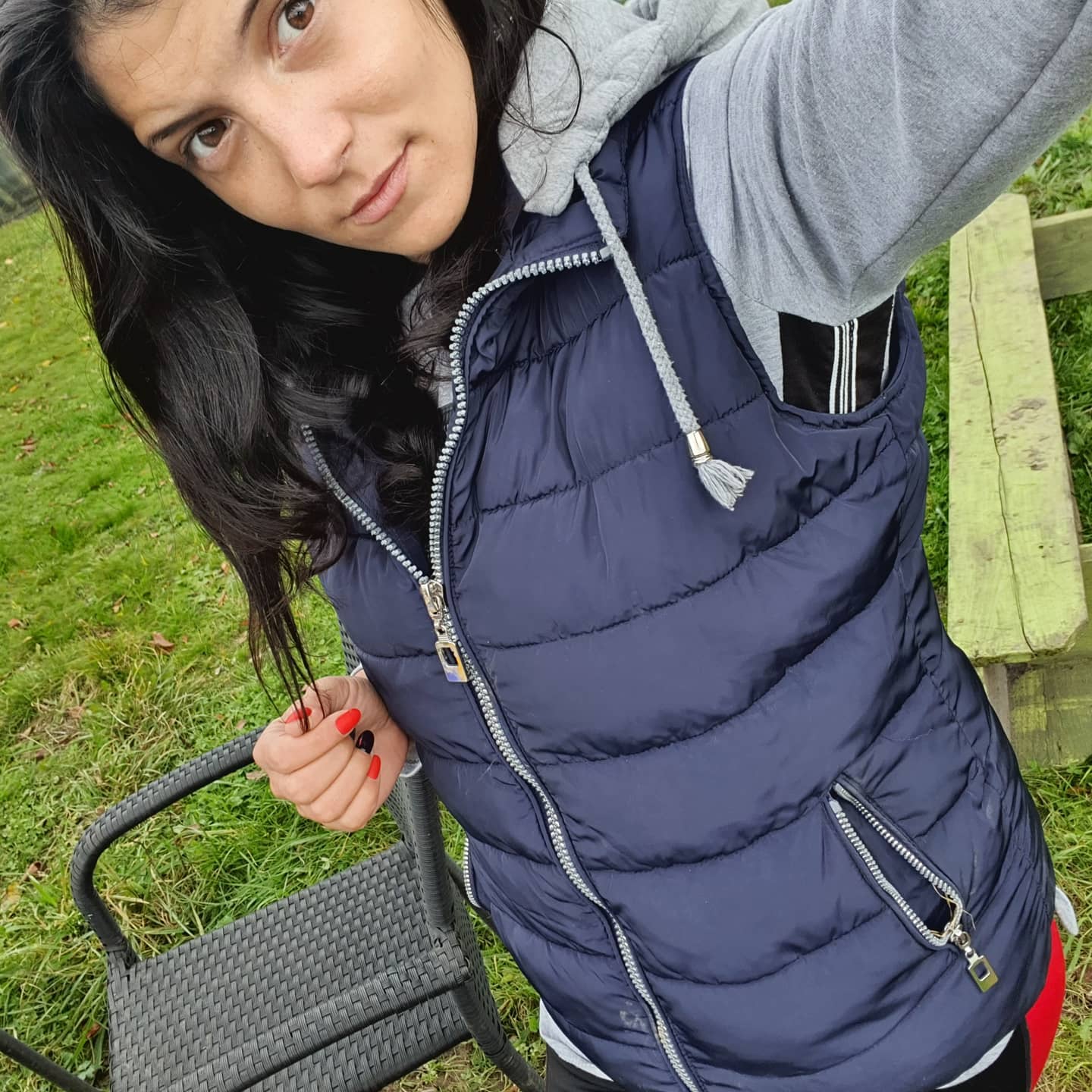 anaworld69 taking a selfie wearing navy blue puffer vest in yard