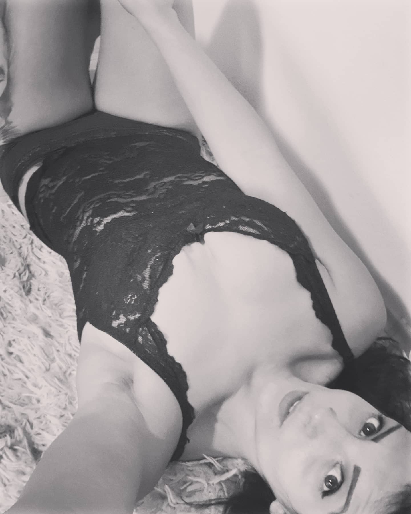 anaworld69 lying on a rug wearing black lace top