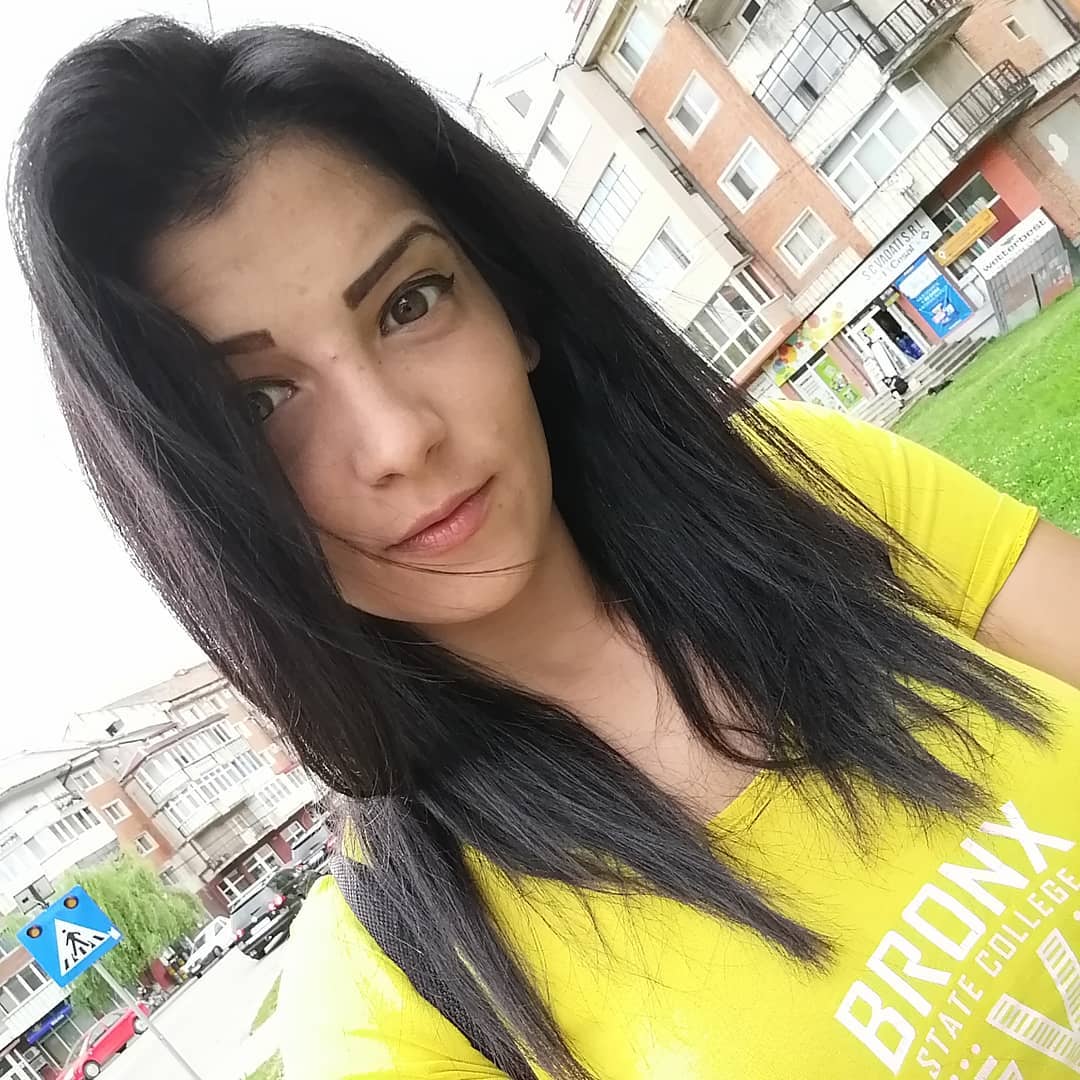 anaworld69 taking a selfie wearing yellow t-shirt in city street