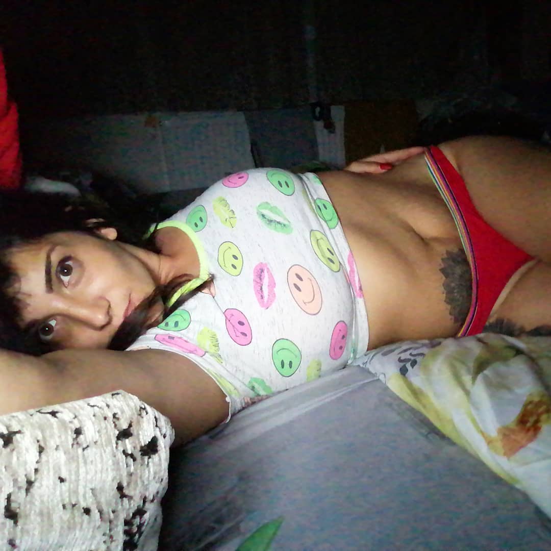 anaworld69 lying on a bed wearing white patterned crop top in bedroom