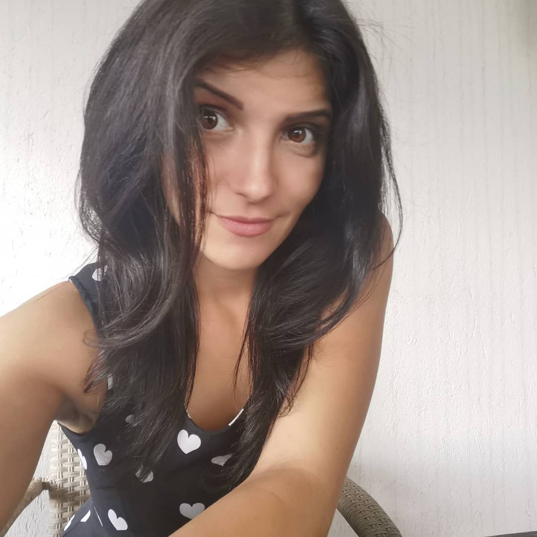 anaworld69 taking a selfie wearing black heart-print top in room