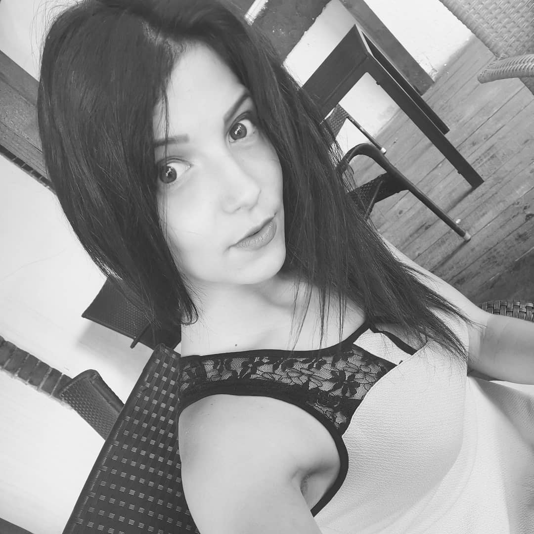 anaworld69 taking a selfie wearing light-colored dress with lace trim in patio