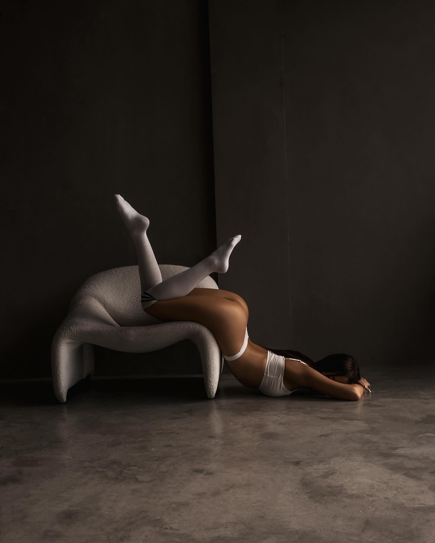 anny54784 lying inverted over a chair onto the floor wearing white underwear set in studio interior