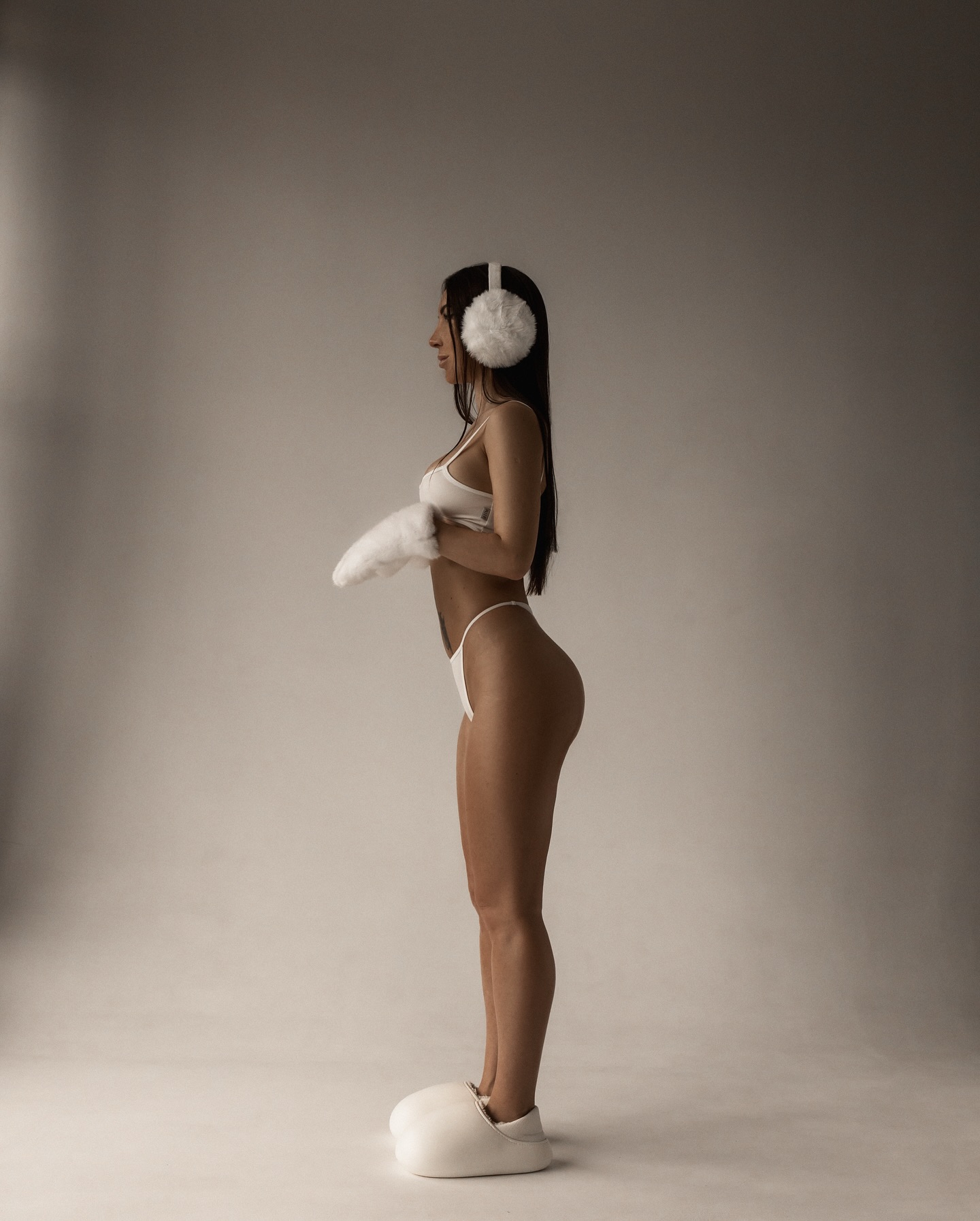anny54784 standing in profile wearing white lingerie in studio