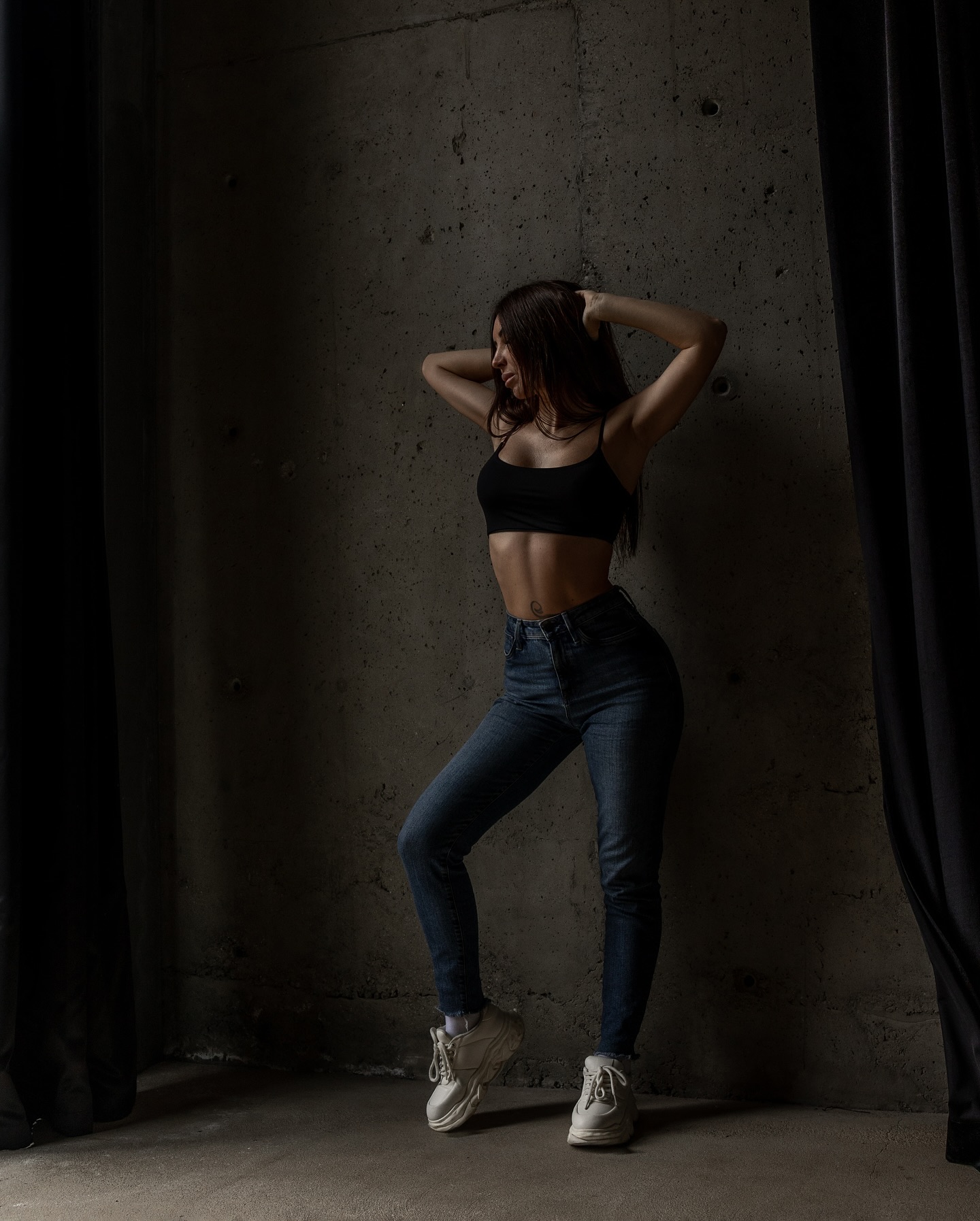anny54784 posing against a concrete wall wearing black crop top in concrete studio
