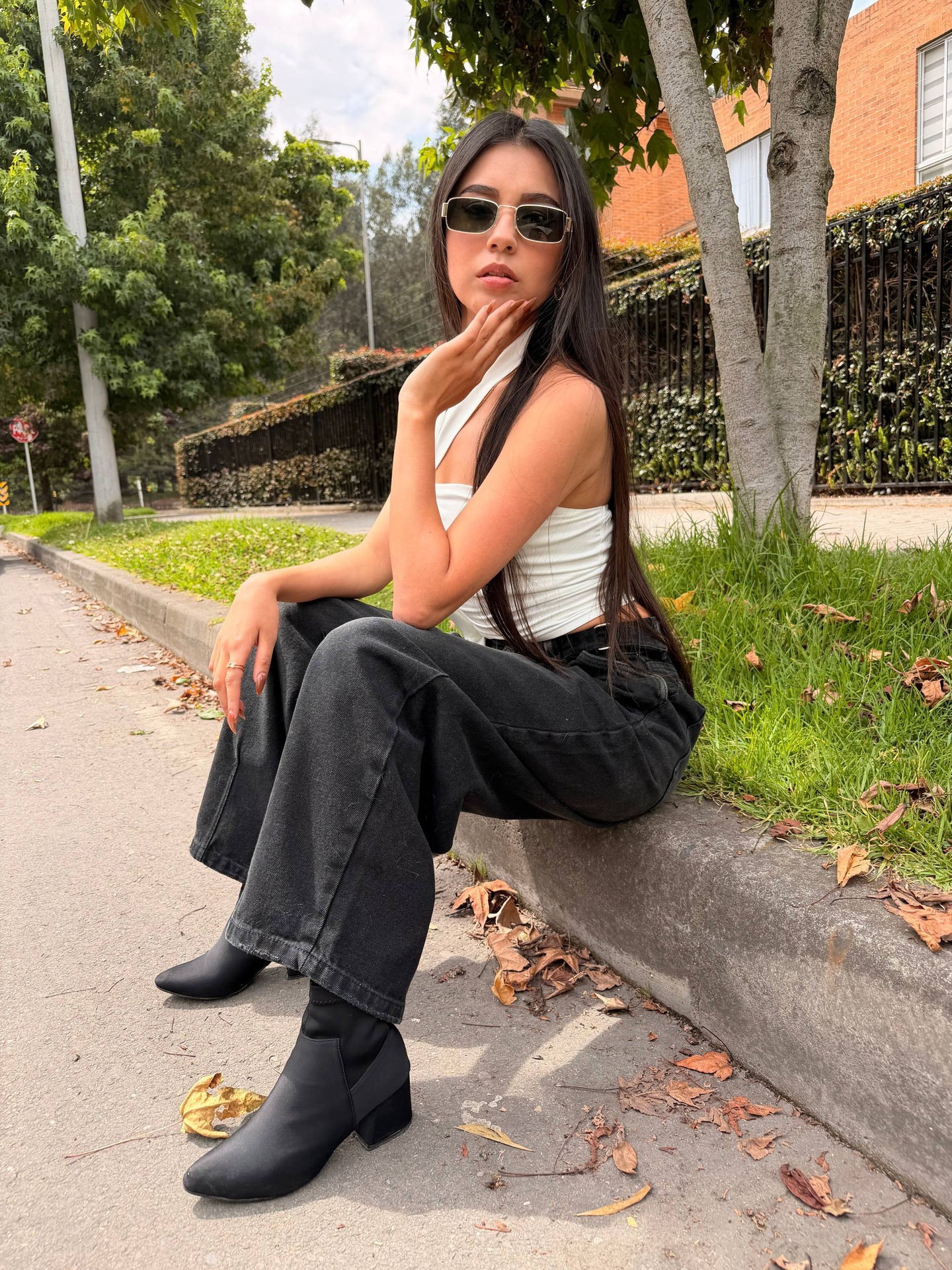 ashley_jones9 sitting on curb wearing white top in sidewalk curb