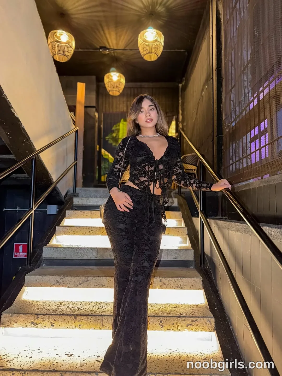 Ale wearing sheer black lace long-sleeve crop top with front tie in staircase in a restaurant in SB Acuario