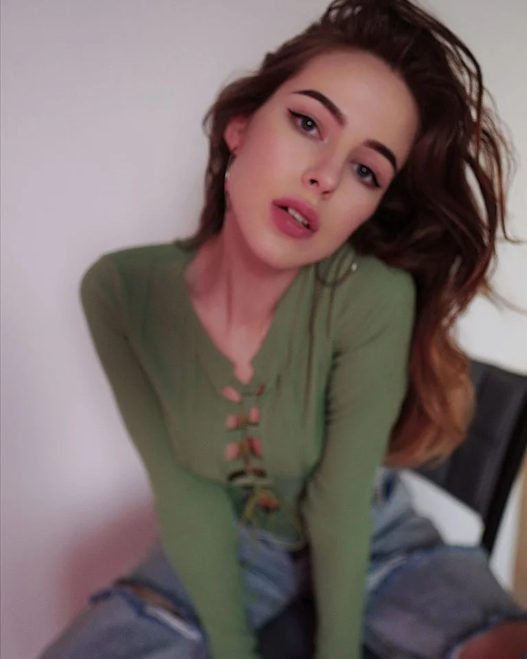 asuna_niiya sitting on chair wearing green long-sleeve top in room