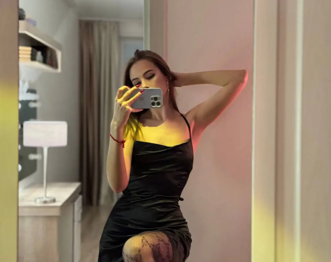 asuna_niiya taking a mirror selfie wearing black slip dress in room
