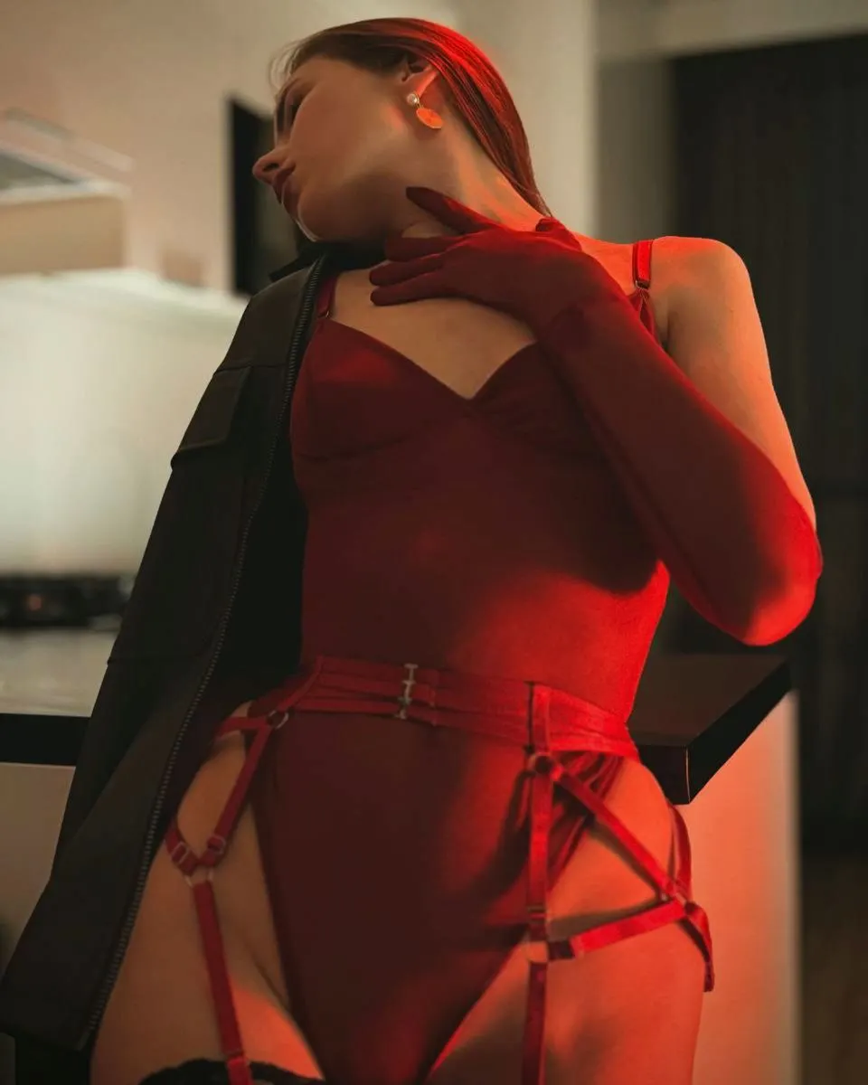 asuna_niiya posing with hand on neck wearing red bodysuit in room