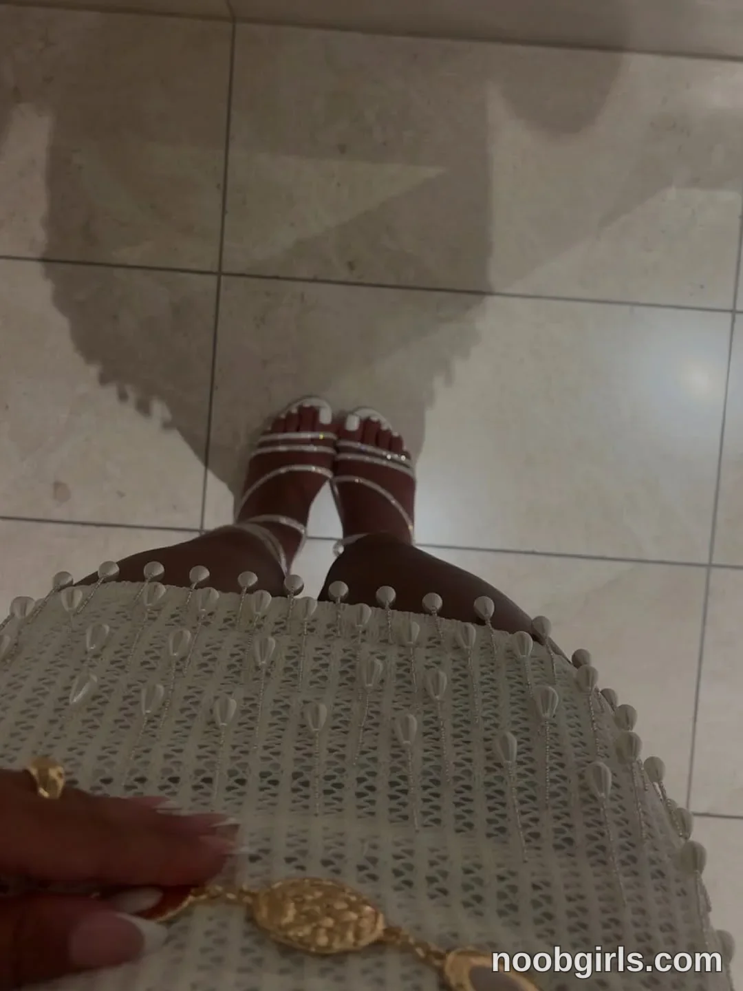 Ava Standing with feet close together wearing Light-coloured crocheted garment with raised oval details in space