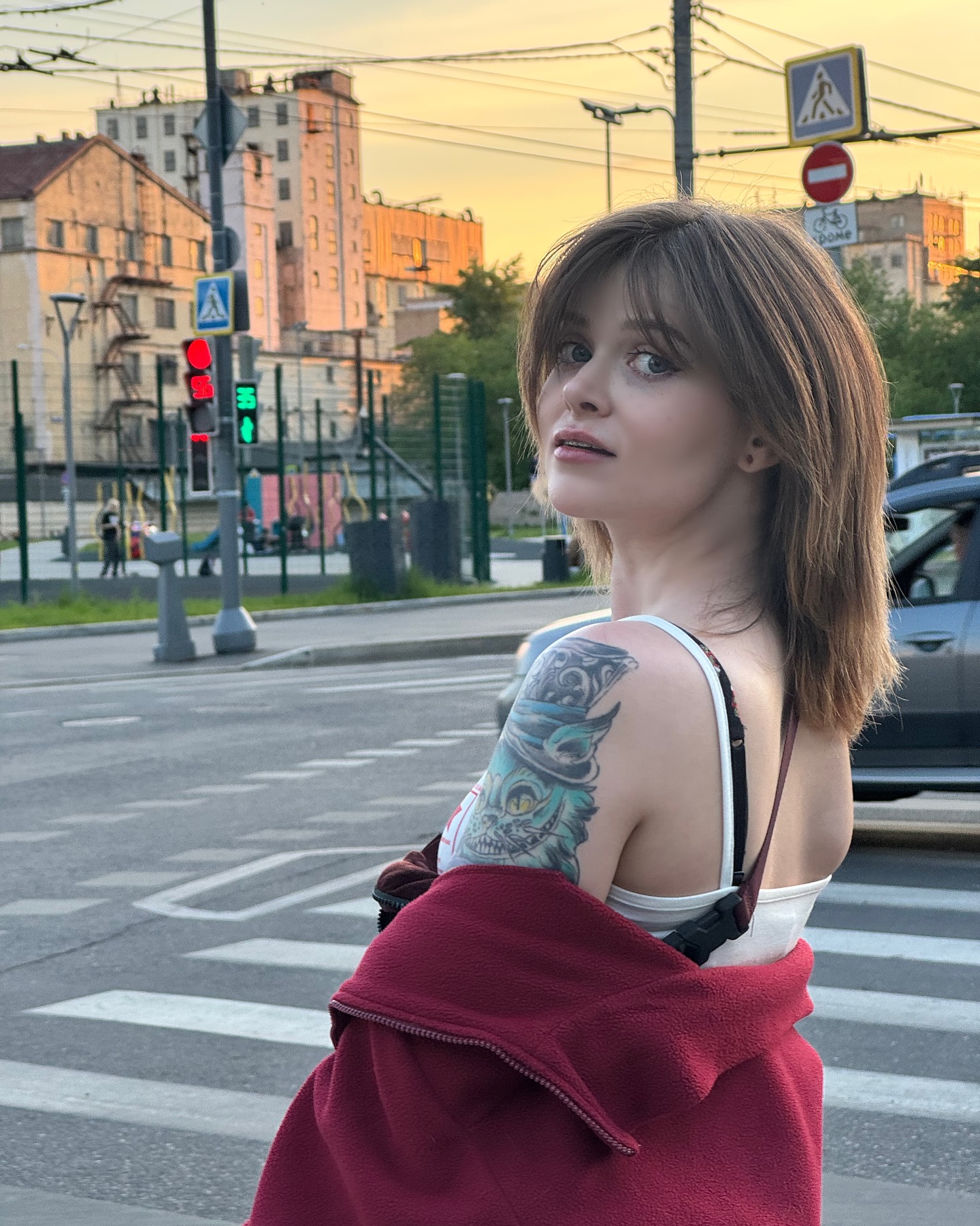 awondrr looking back over shoulder wearing white tank top in city street crosswalk