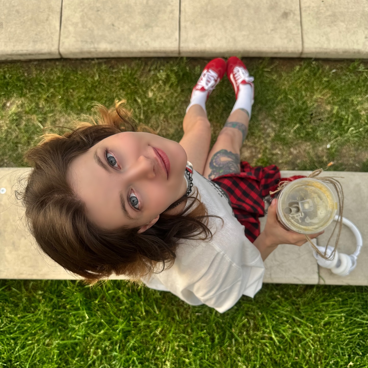 awondrr holding a drink wearing white t-shirt in ledge
