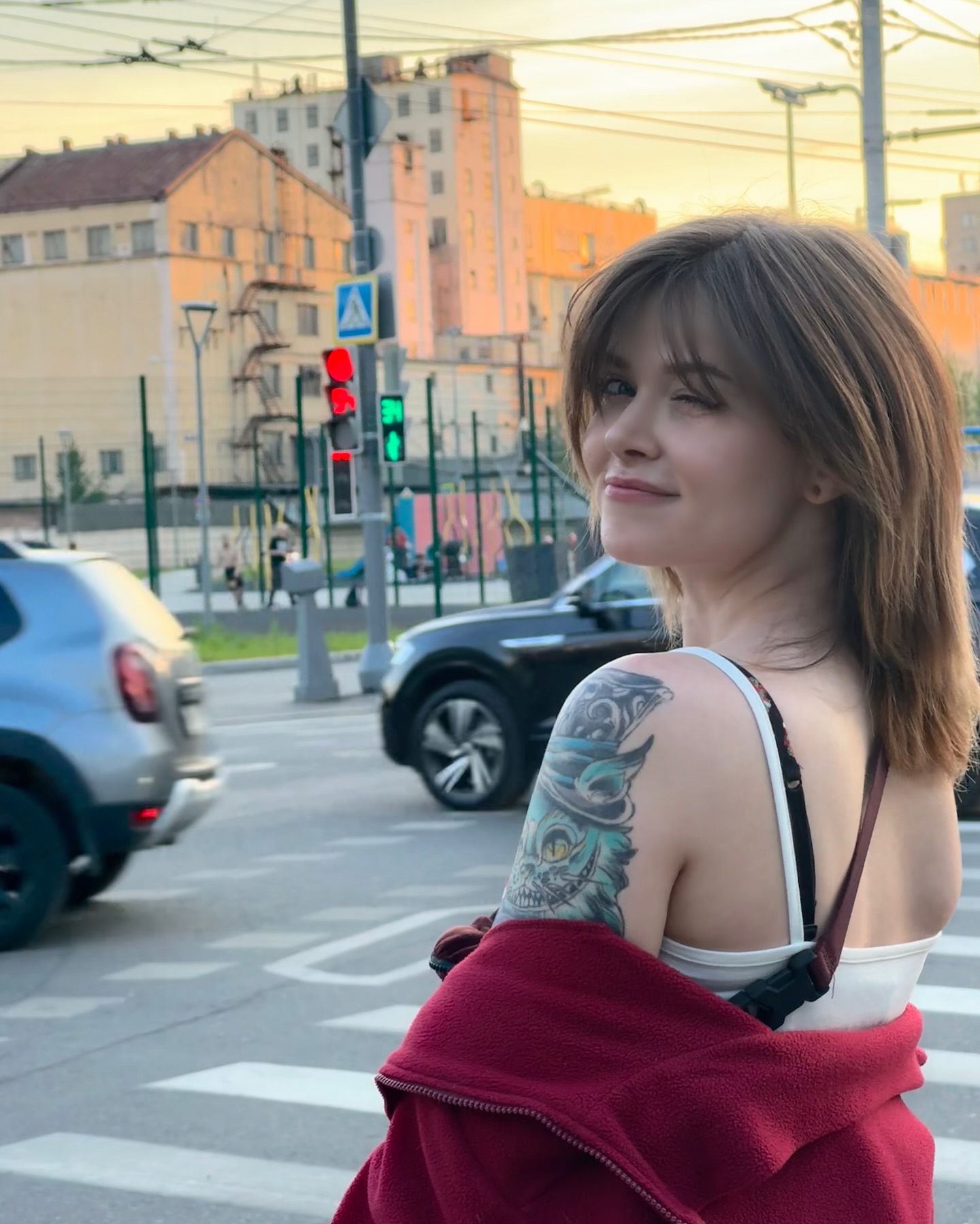 awondrr looking over shoulder wearing white tank top in city street