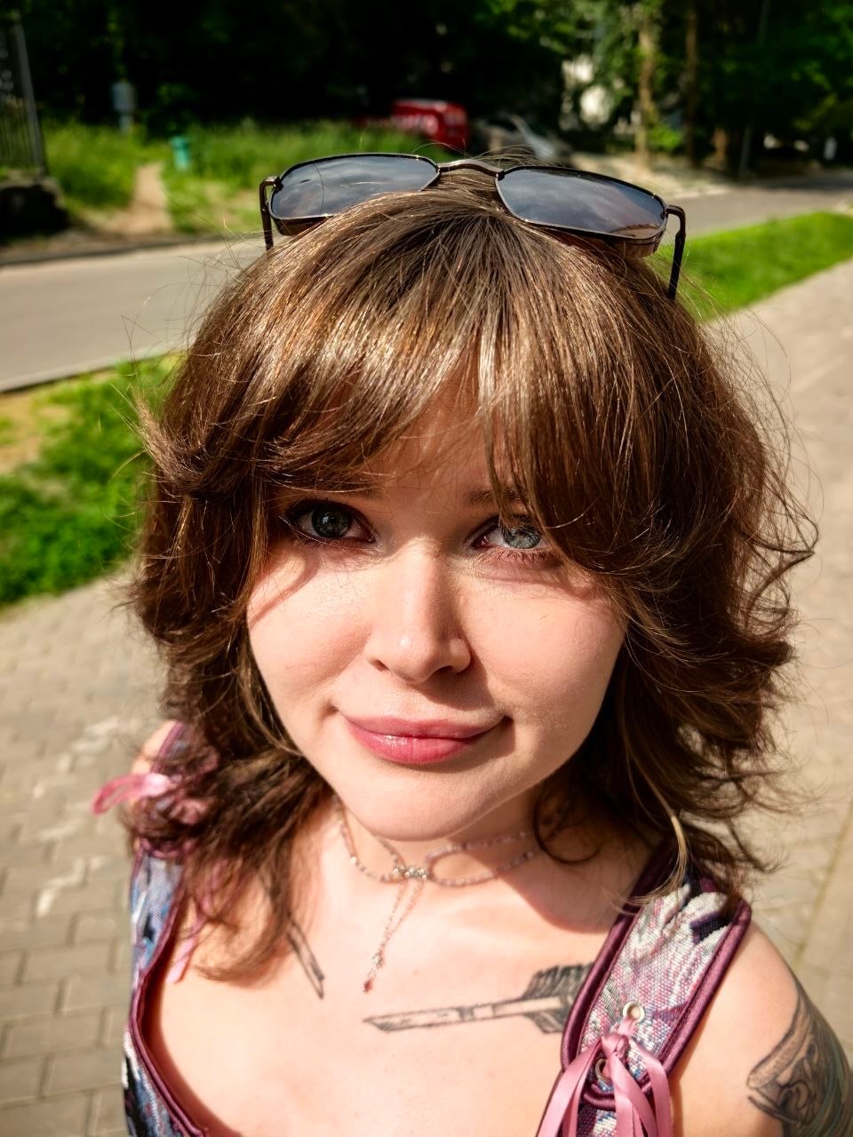 awondrr wearing sunglasses on head in paved walkway outdoors