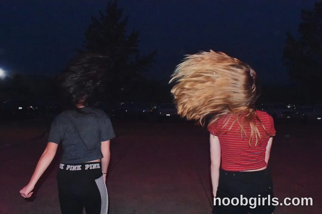 Britt flipping hair wearing grey t-shirt in parking lot at night
