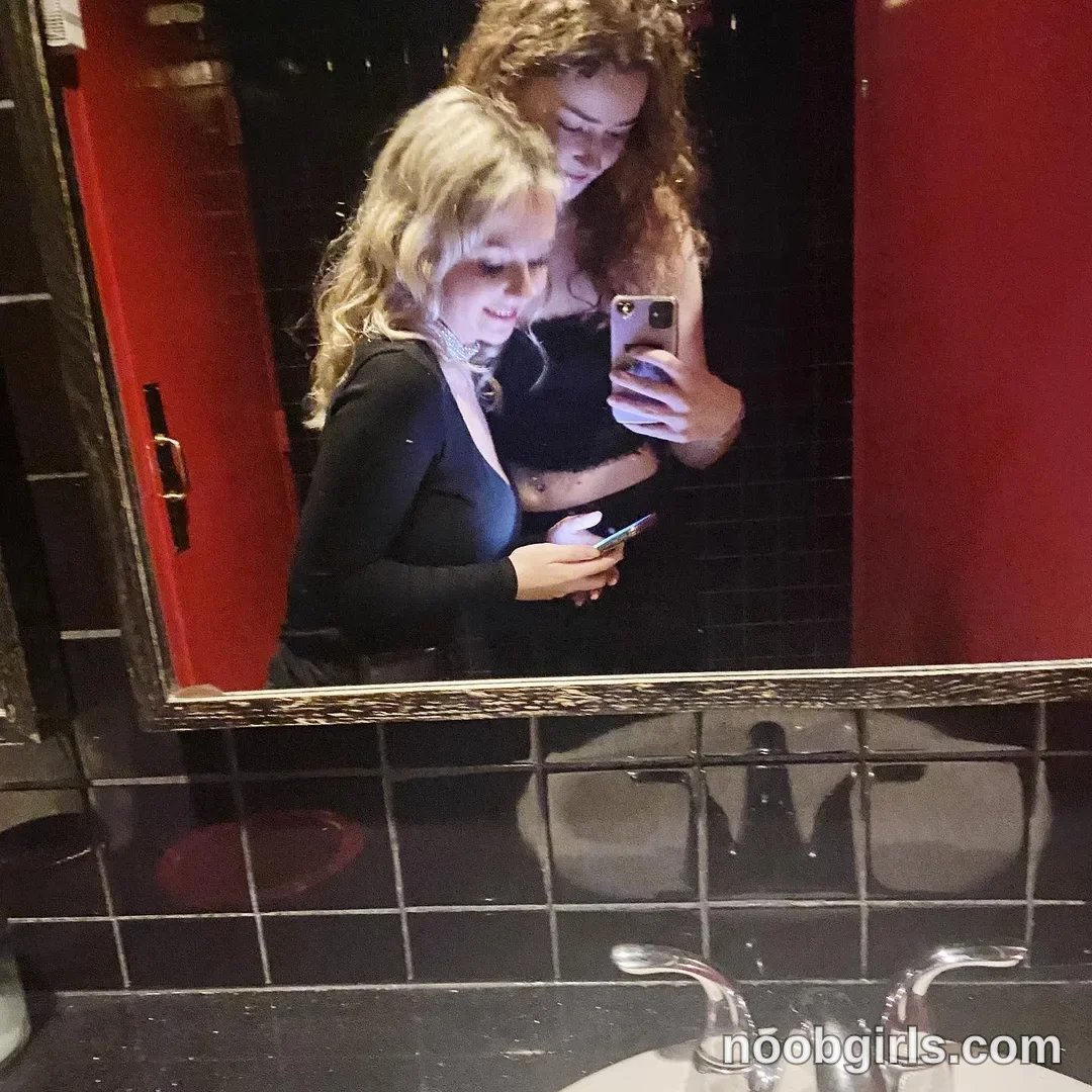Britt taking a mirror selfie wearing black long-sleeved top in restroom