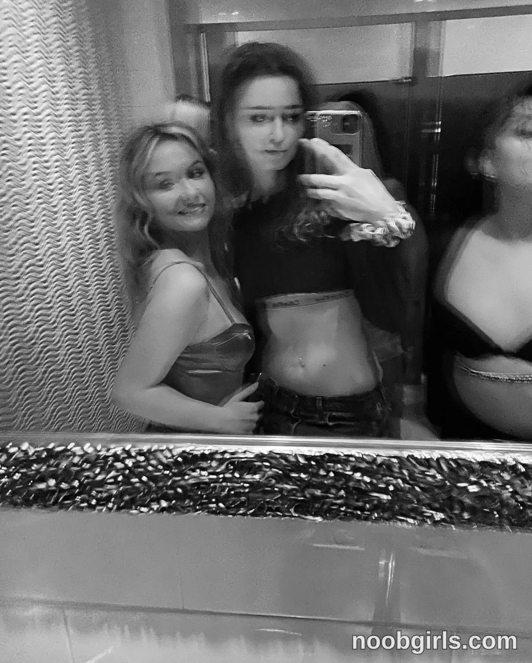 Britt taking a mirror selfie wearing crop top in bathroom