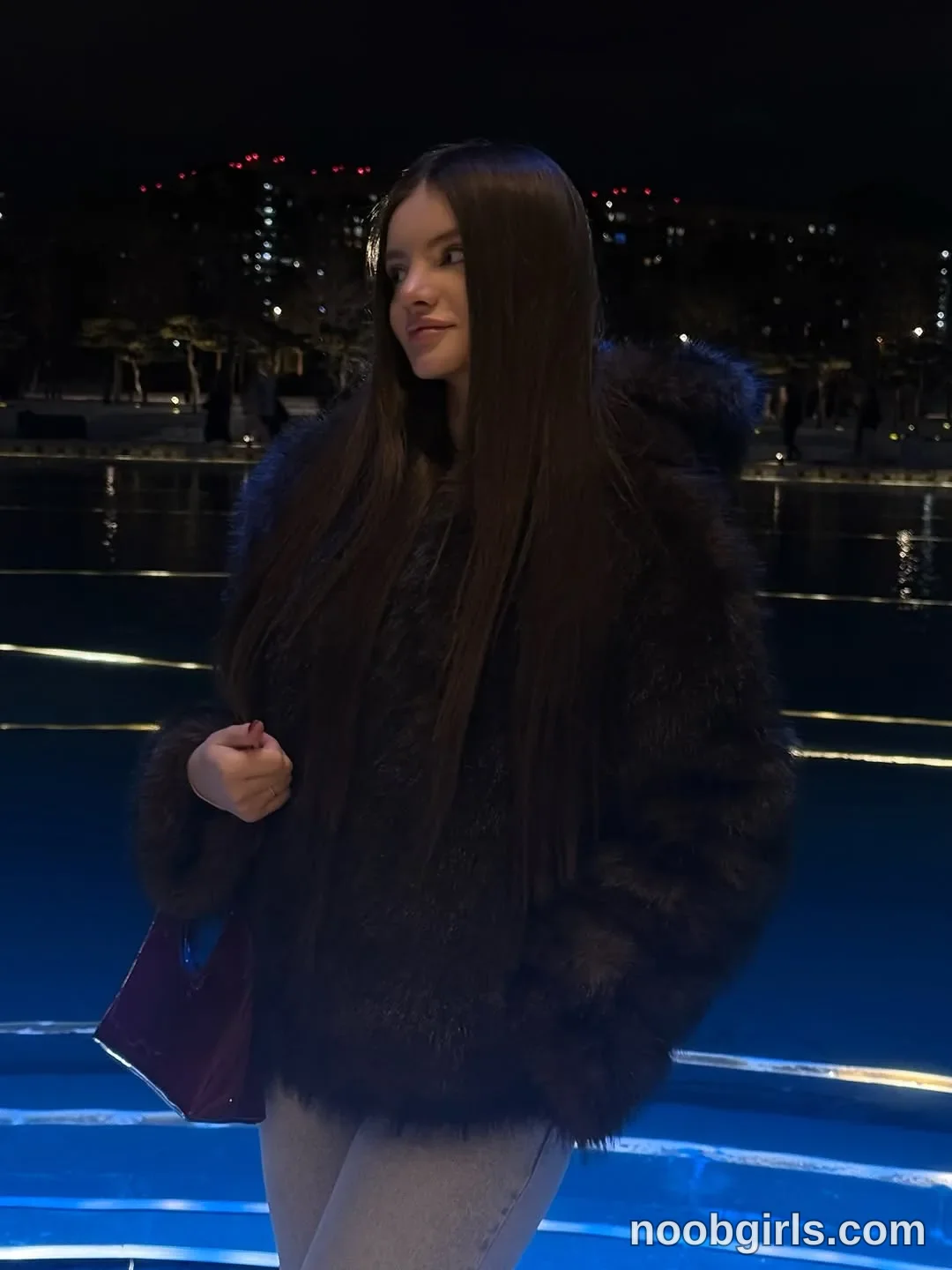 bellacle wearing dark brown or black faux fur or shaggy jacket with a hood