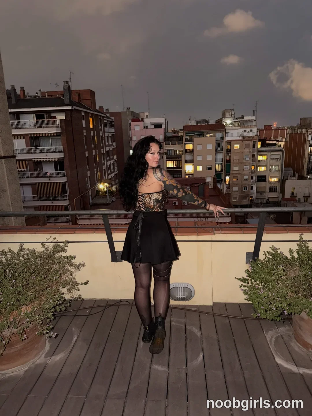 bexbex945874 standing by a railing wearing patterned corset top in rooftop balcony