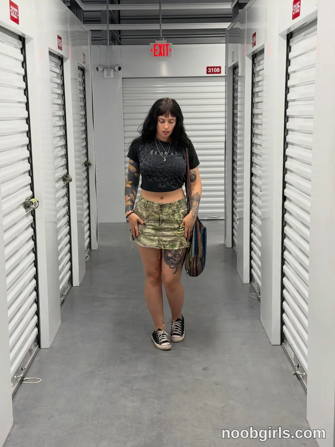 bexbex945874 walking forward wearing black crop t-shirt in storage facility hallway