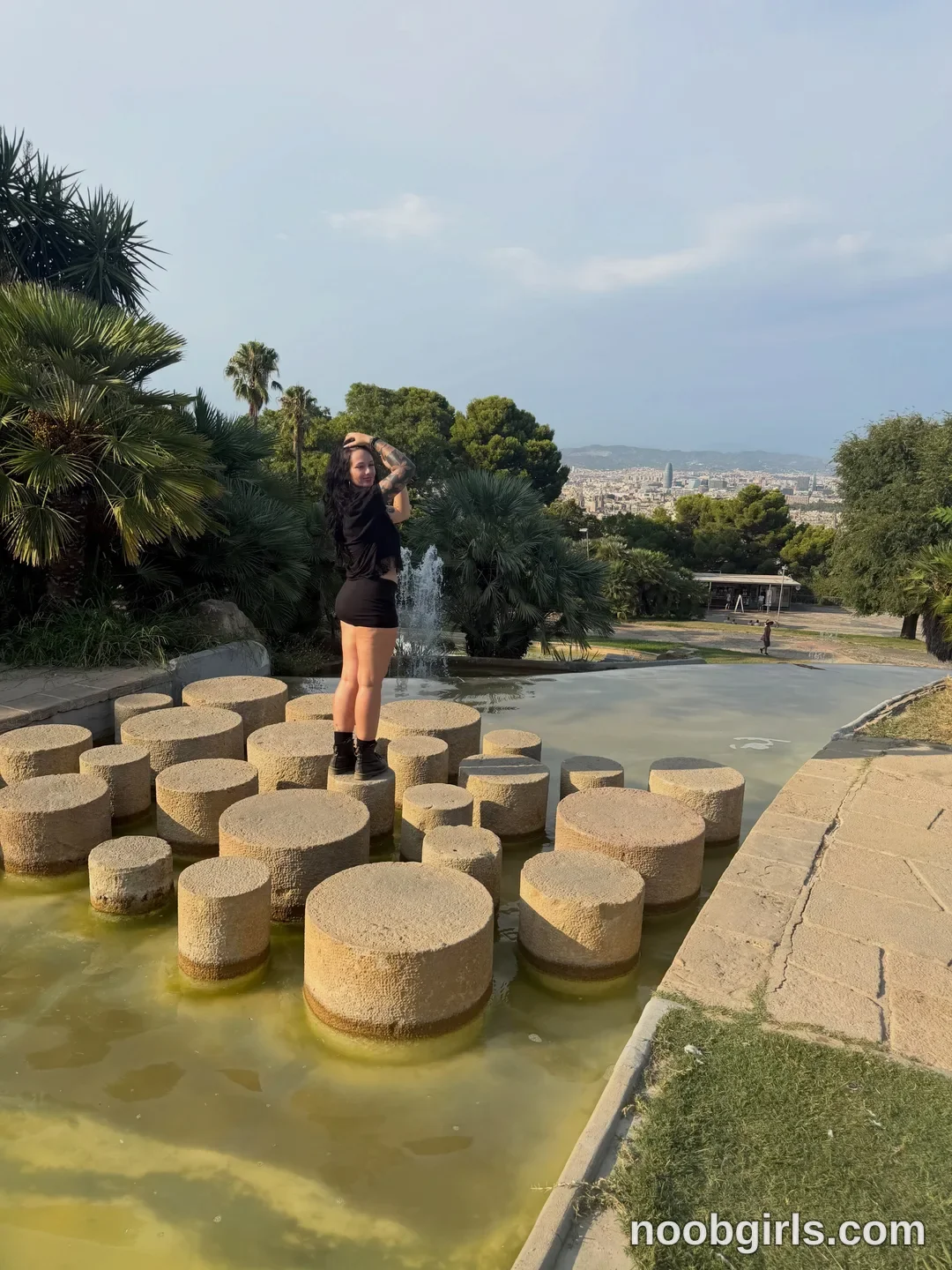 bexbex945874 posing on stone fountain pillars wearing black t-shirt in park fountain at Montjuïc, Barcelona