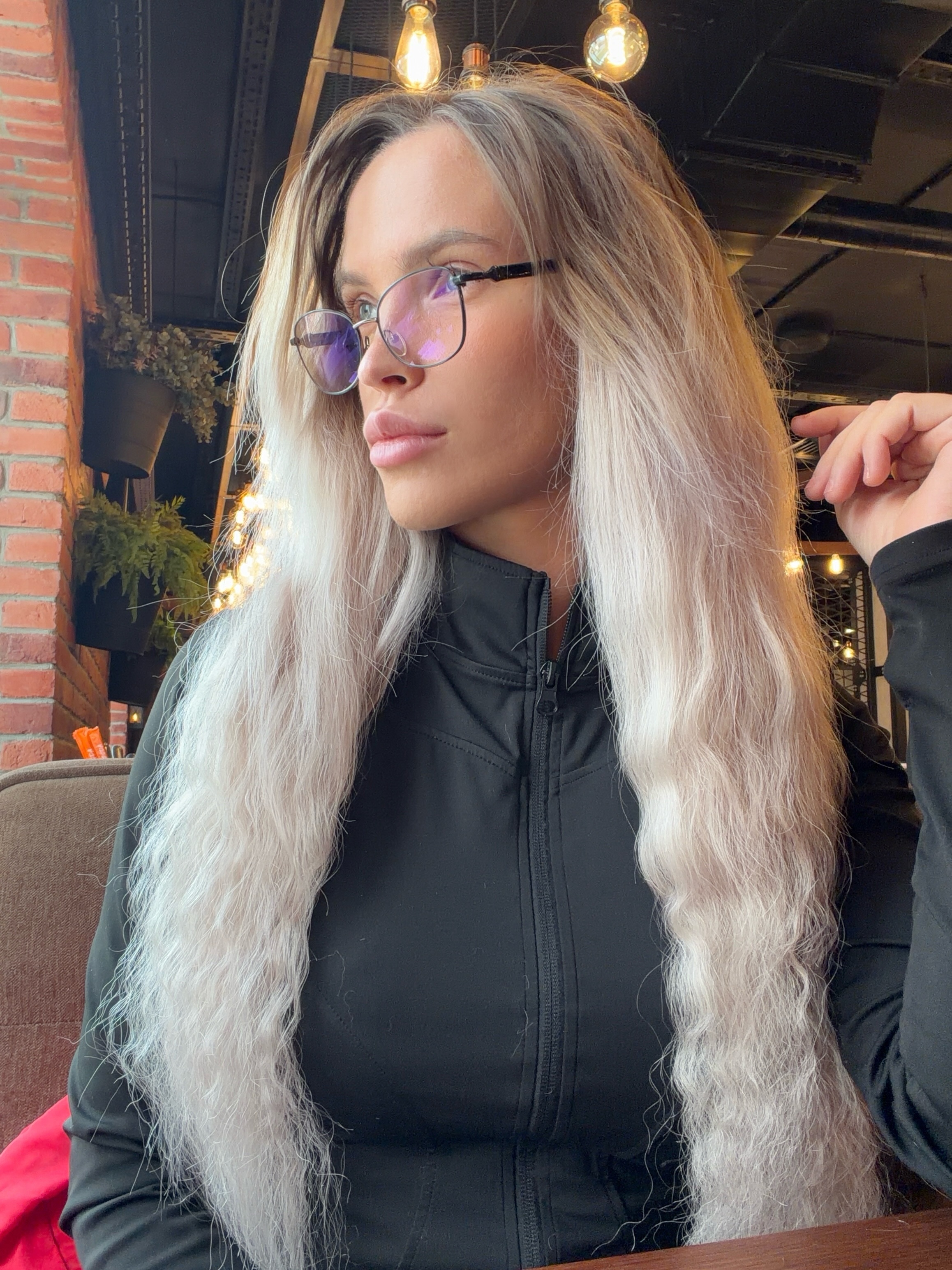 blush_mikki sitting at table wearing black zip-up jacket in cafe interior