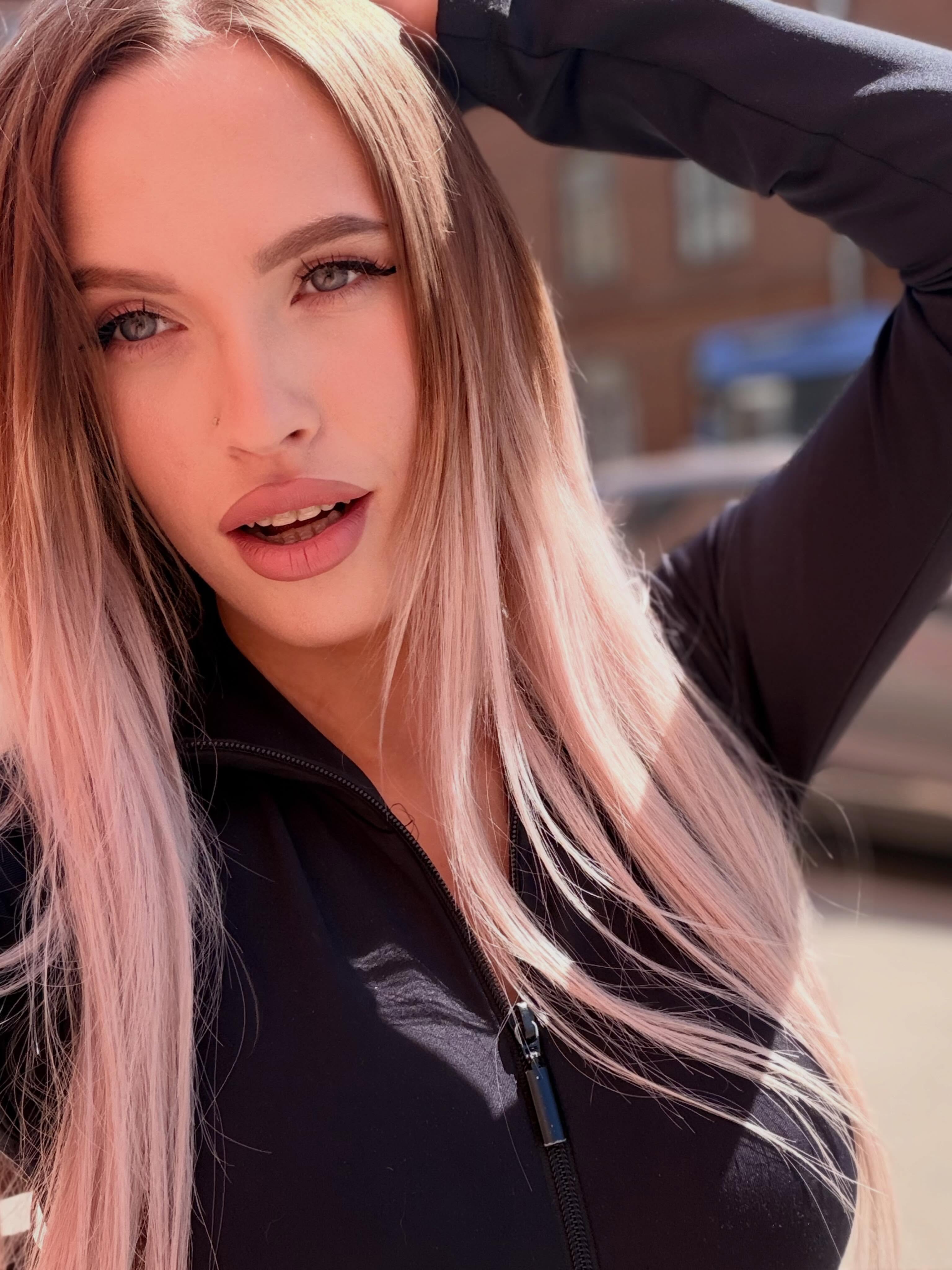 blush_mikki posing with hand on head wearing black zip-up top