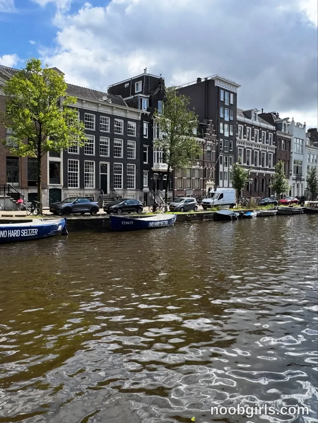 BunnyBlondyX No identifiable woman is visible. in urban canal bordered by a street and multistorey buildings