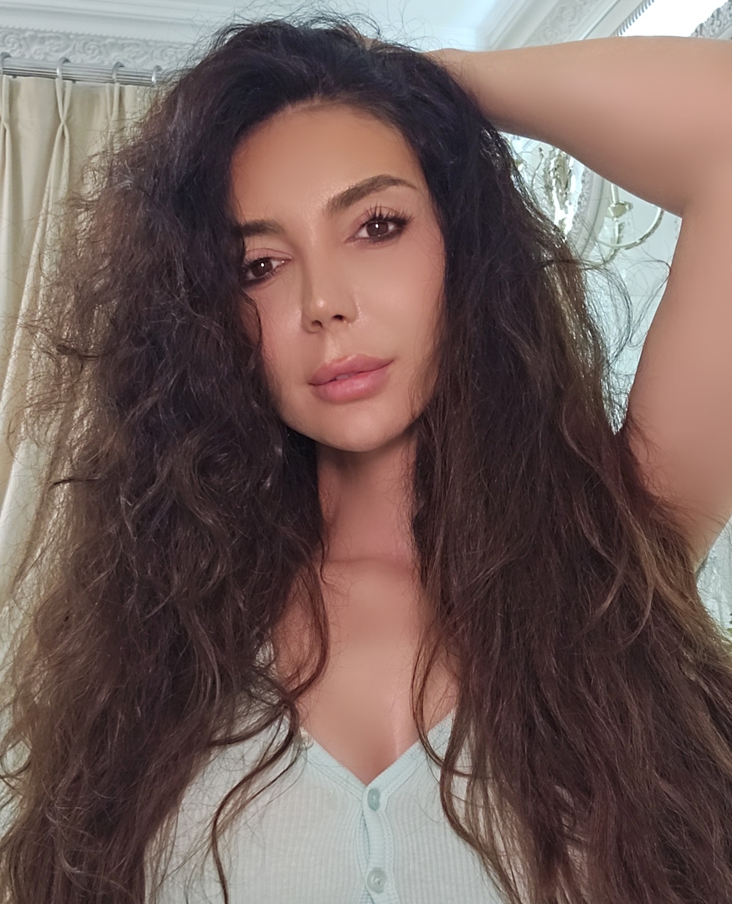 caylin posing with hand behind head wearing light green top