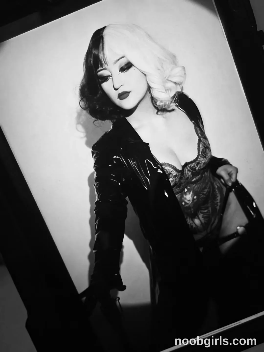 charlotte_germanotta_ Standing with her head turned to the side wearing Black glossy long-sleeved coat