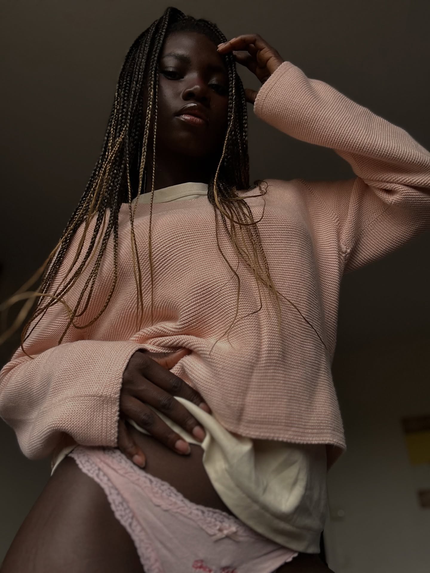 conymegan posing looking down at camera wearing pink knit sweater