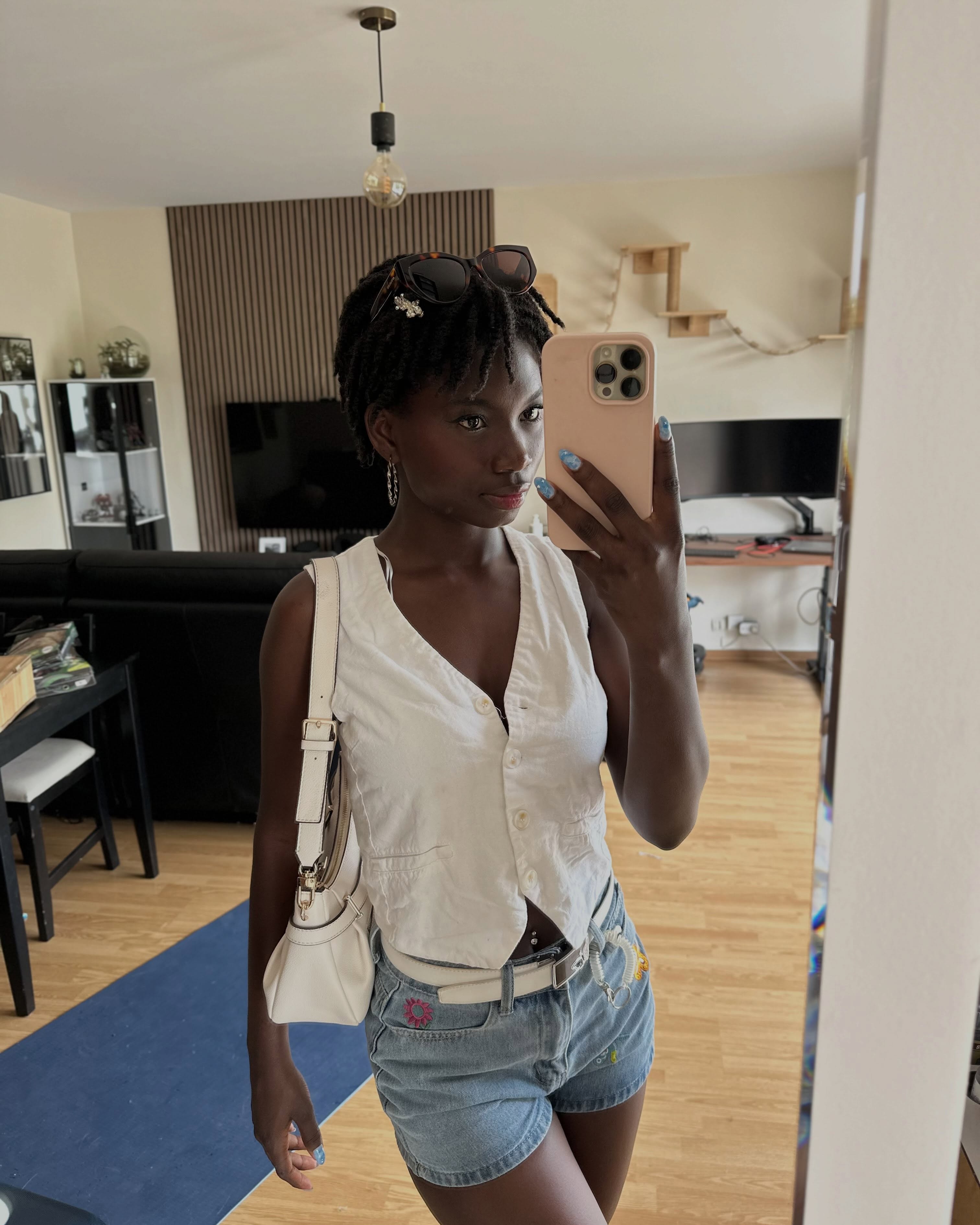 conymegan taking a mirror selfie wearing white vest in living room