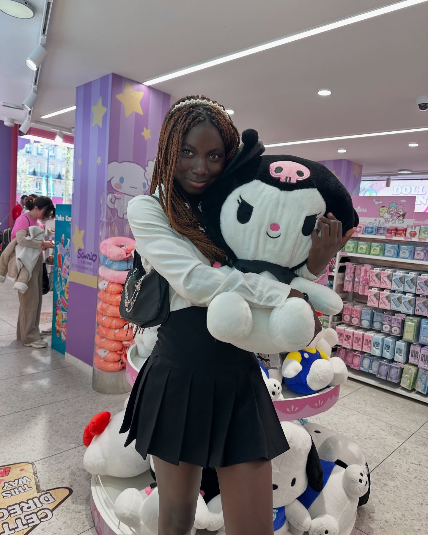 conymegan holding a large plush toy wearing white button-up shirt in toy store