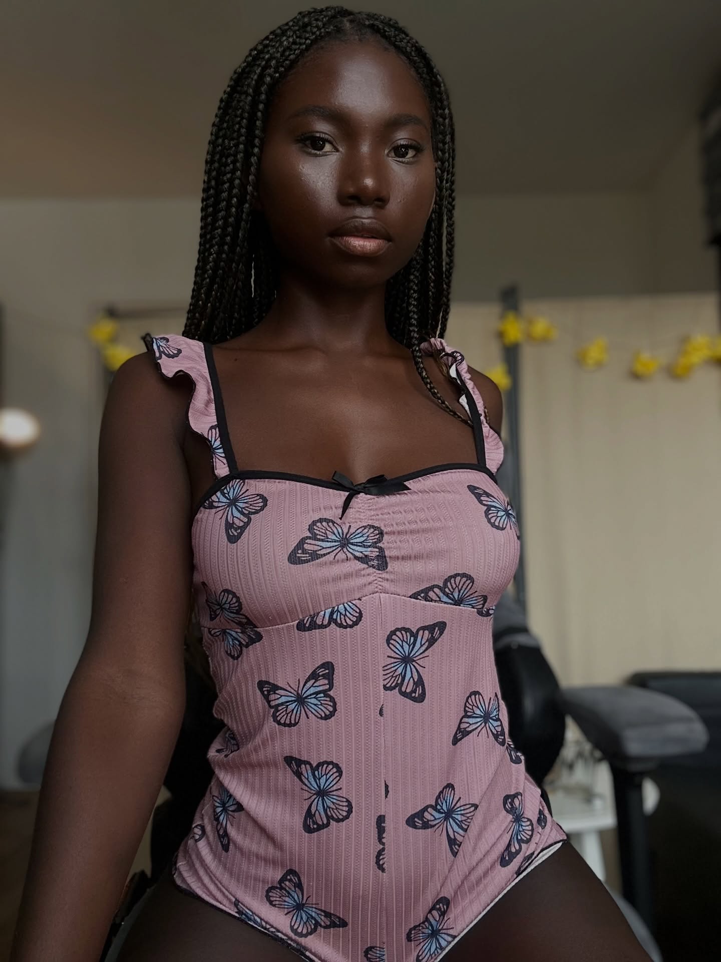 conymegan wearing pink butterfly print bodysuit in room