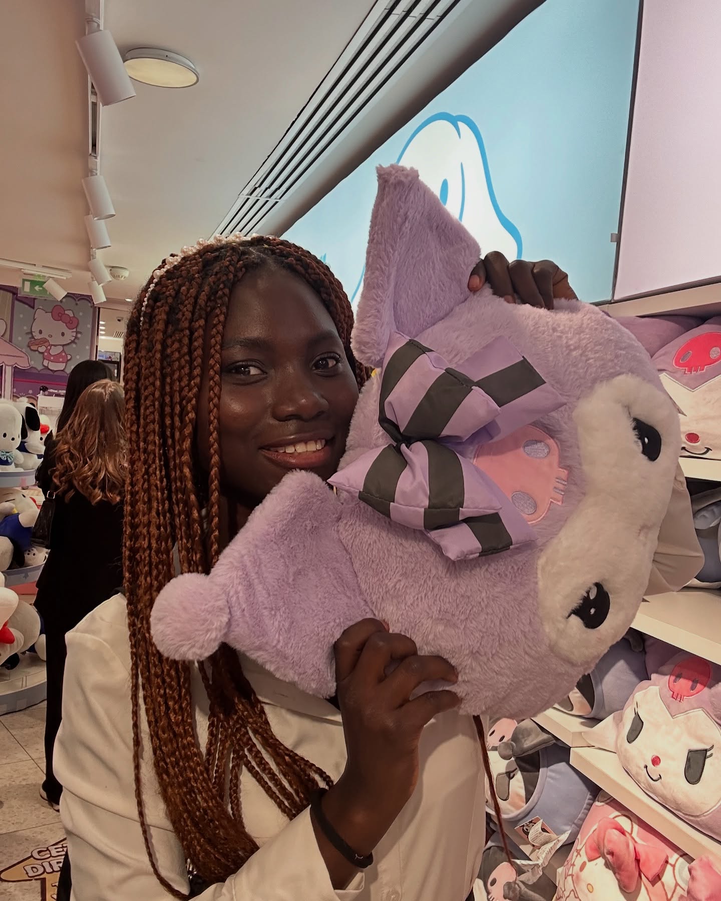 conymegan holding a purple plush toy wearing white shirt in toy store