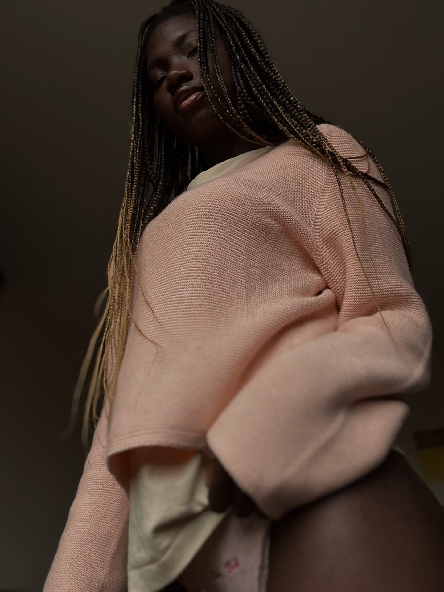 conymegan looking down at camera wearing pink knit sweater