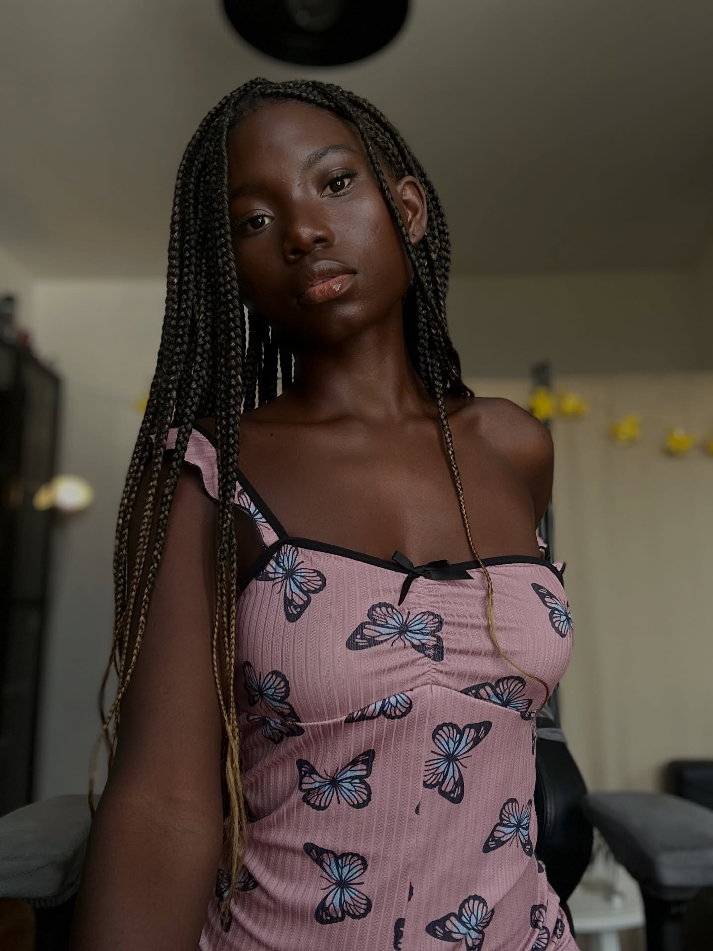 conymegan wearing pink butterfly print dress in room