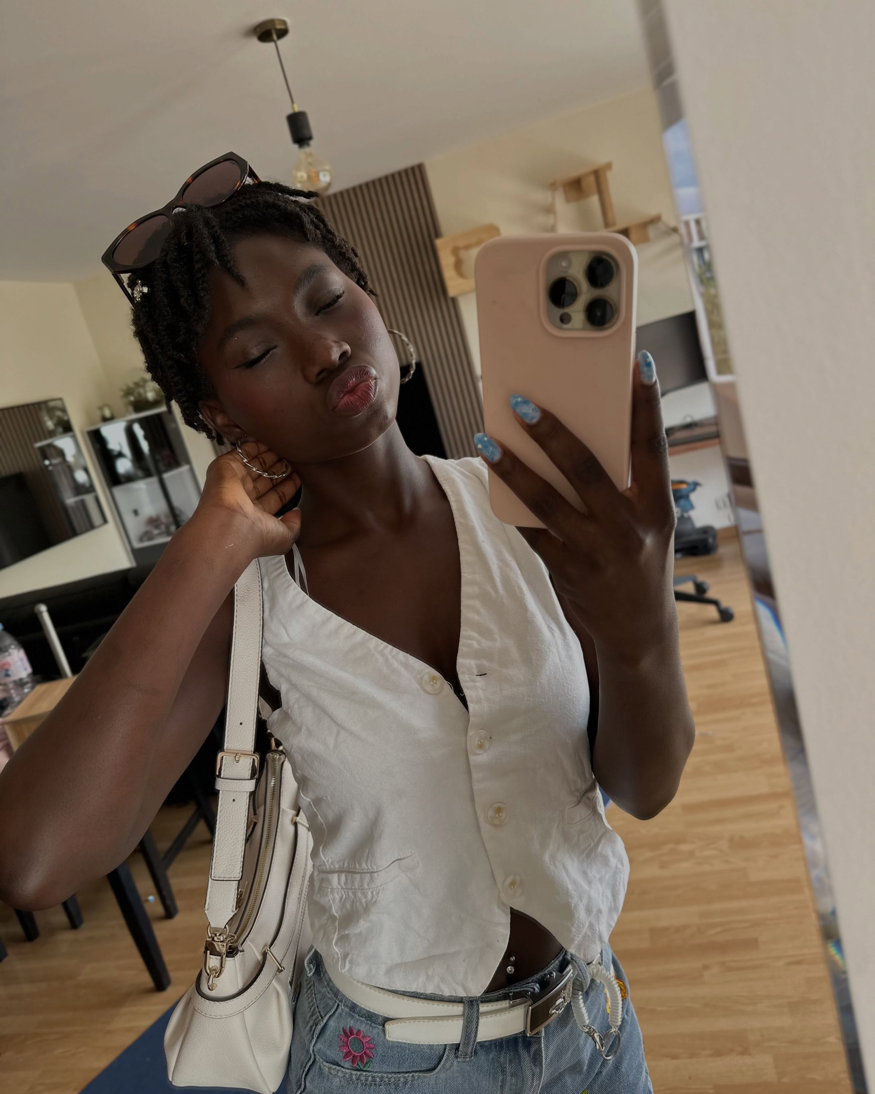 conymegan taking a mirror selfie wearing white sleeveless vest in living room