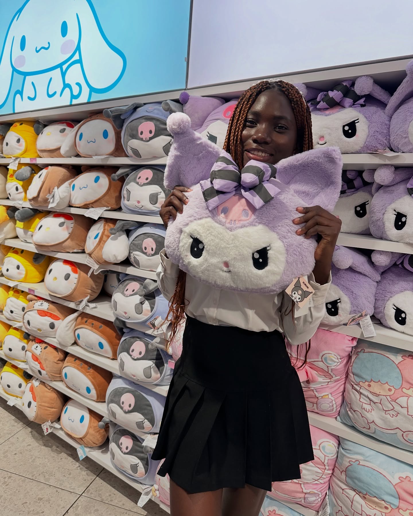 conymegan holding a plush cushion wearing white collared shirt in toy store