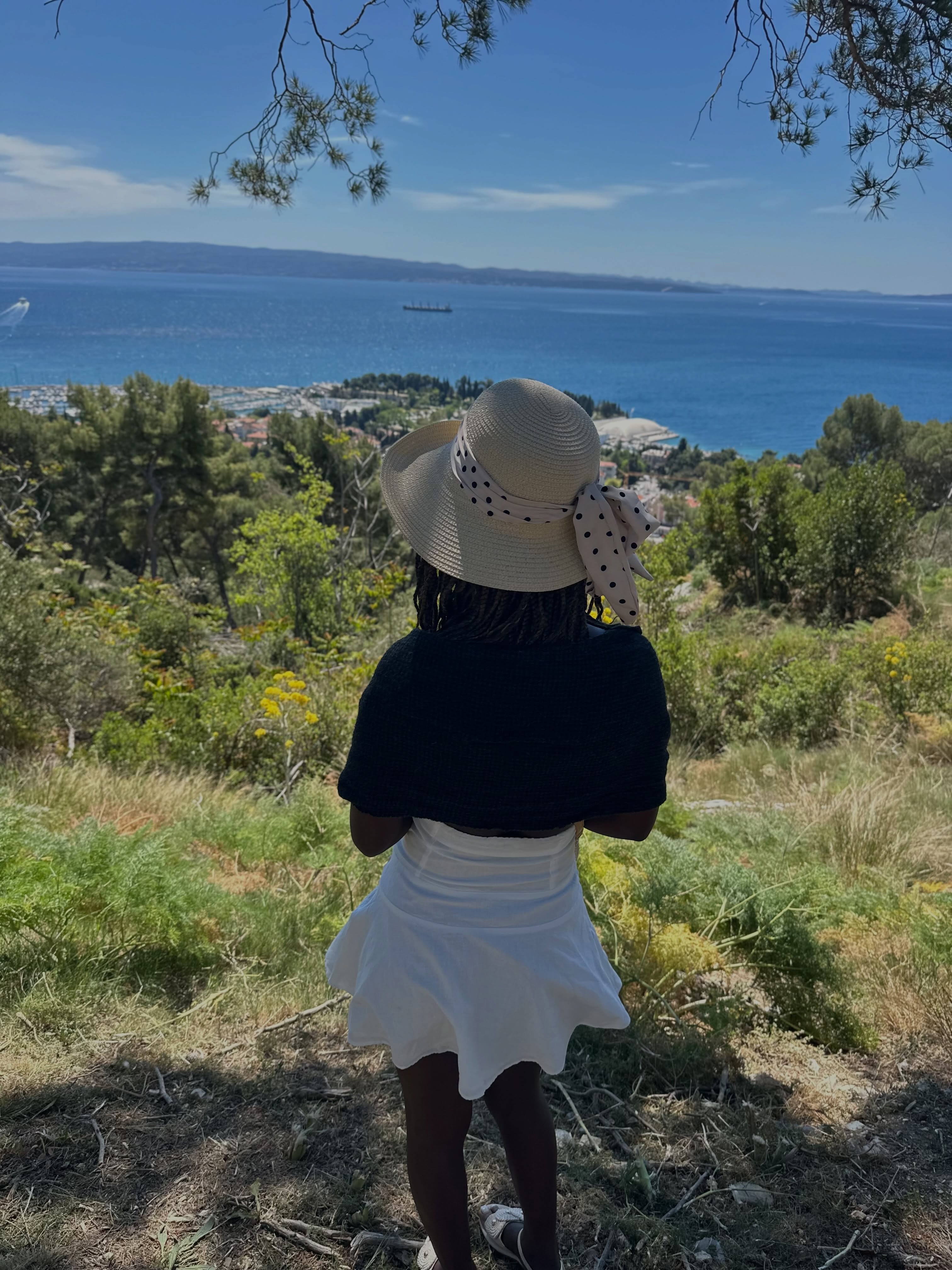conymegan wearing straw sun hat in hillside overlooking the sea