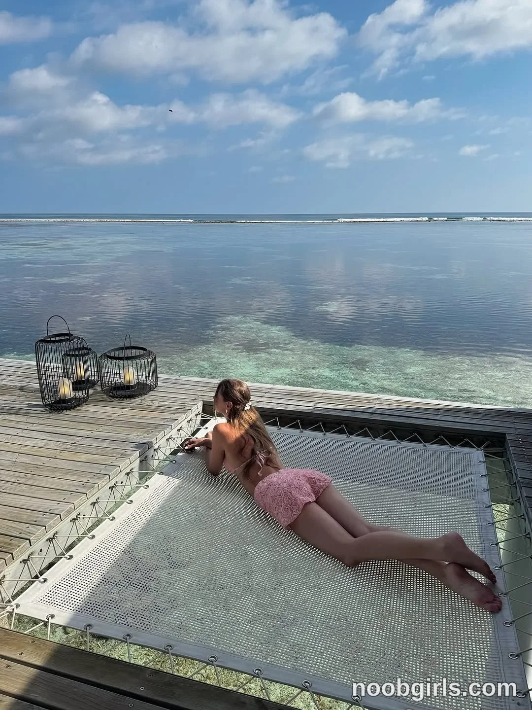 CoverM lying on her stomach on the suspended net wearing Pink bikini top with thin straps